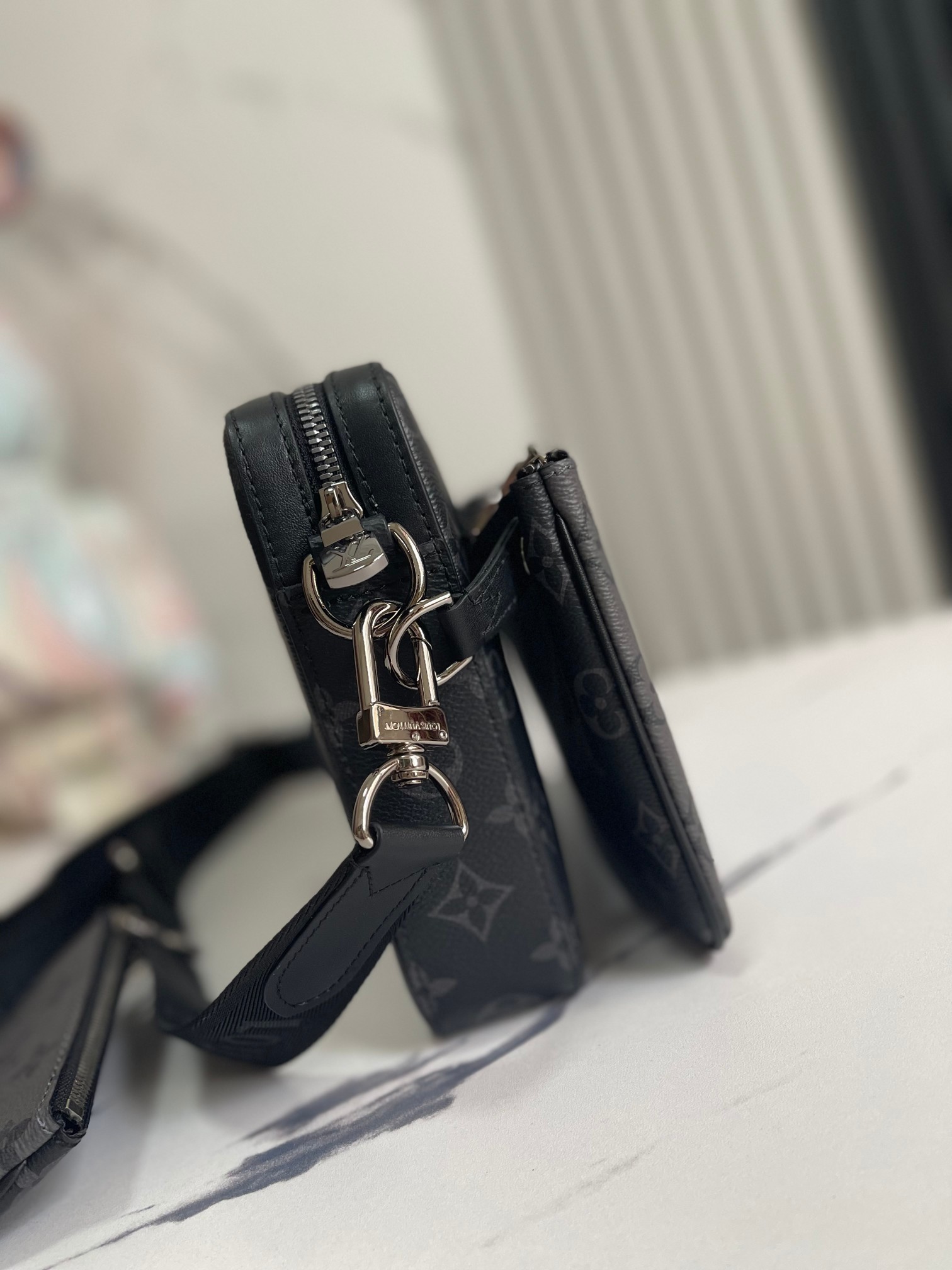 P400【顶级外‬单 独‮实家‬拍】 M69443黑灰 Trio 邮差包由 Monogram Eclipse 帆布与 Monogram Eclipse Reverse 帆布制成。标志性的同色调灰色图案凸显此多功能拼搭设计品的线条。除具备传统斜跨手袋的功能外，另配可脱卸拉链袋和附于包带上的零钱包。小包：12×7 cm中包：24×15 cm大包：26×5×18 cm