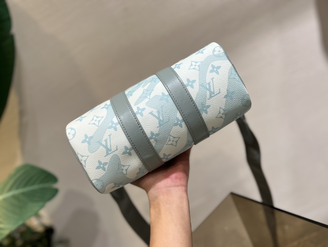 M22527 46271 滴水绿 本款 Keepall Bandoulière 25 手袋依托创意喷墨印制工艺,仿佛水滴滑过 LV 字母和 4