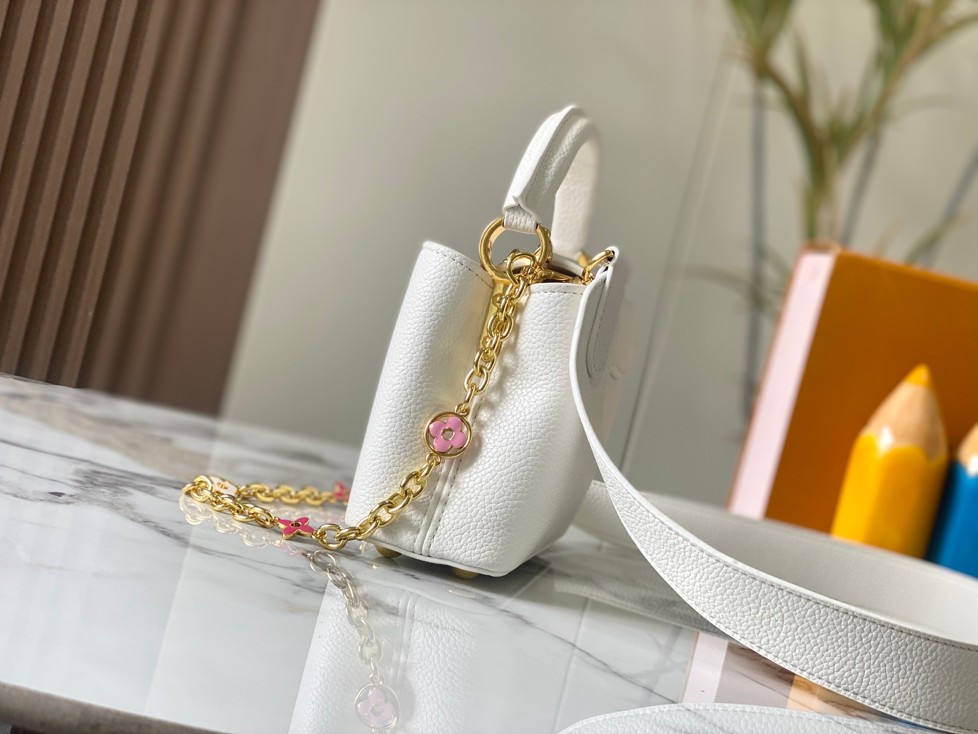 升级版 M20845白色花卉
本款 Cap-ucines 迷你手袋展现柔婉之美：Taurillon 皮革