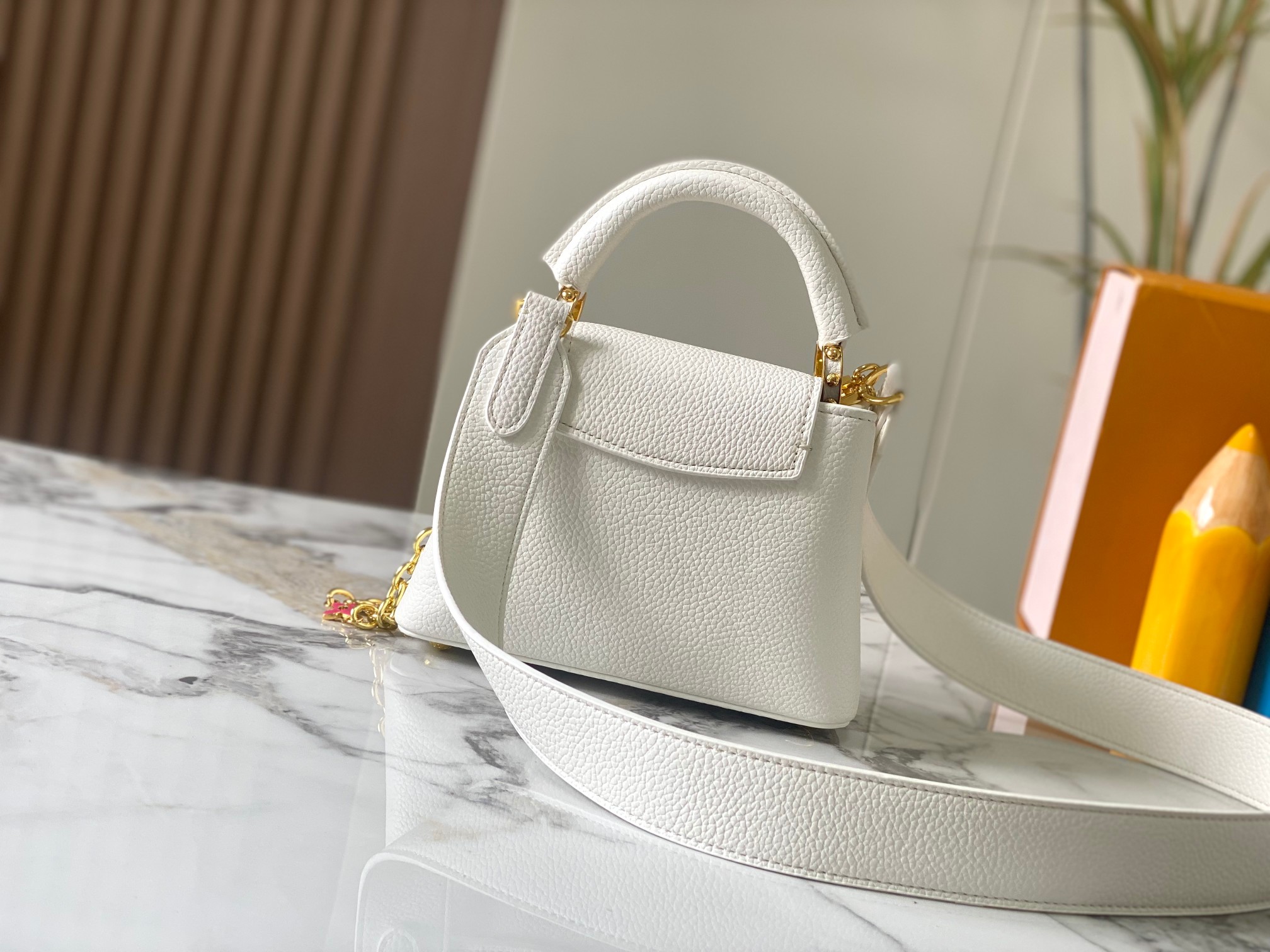 升级版 M20845白色花卉
本款 Cap-ucines 迷你手袋展现柔婉之美：Taurillon 皮革