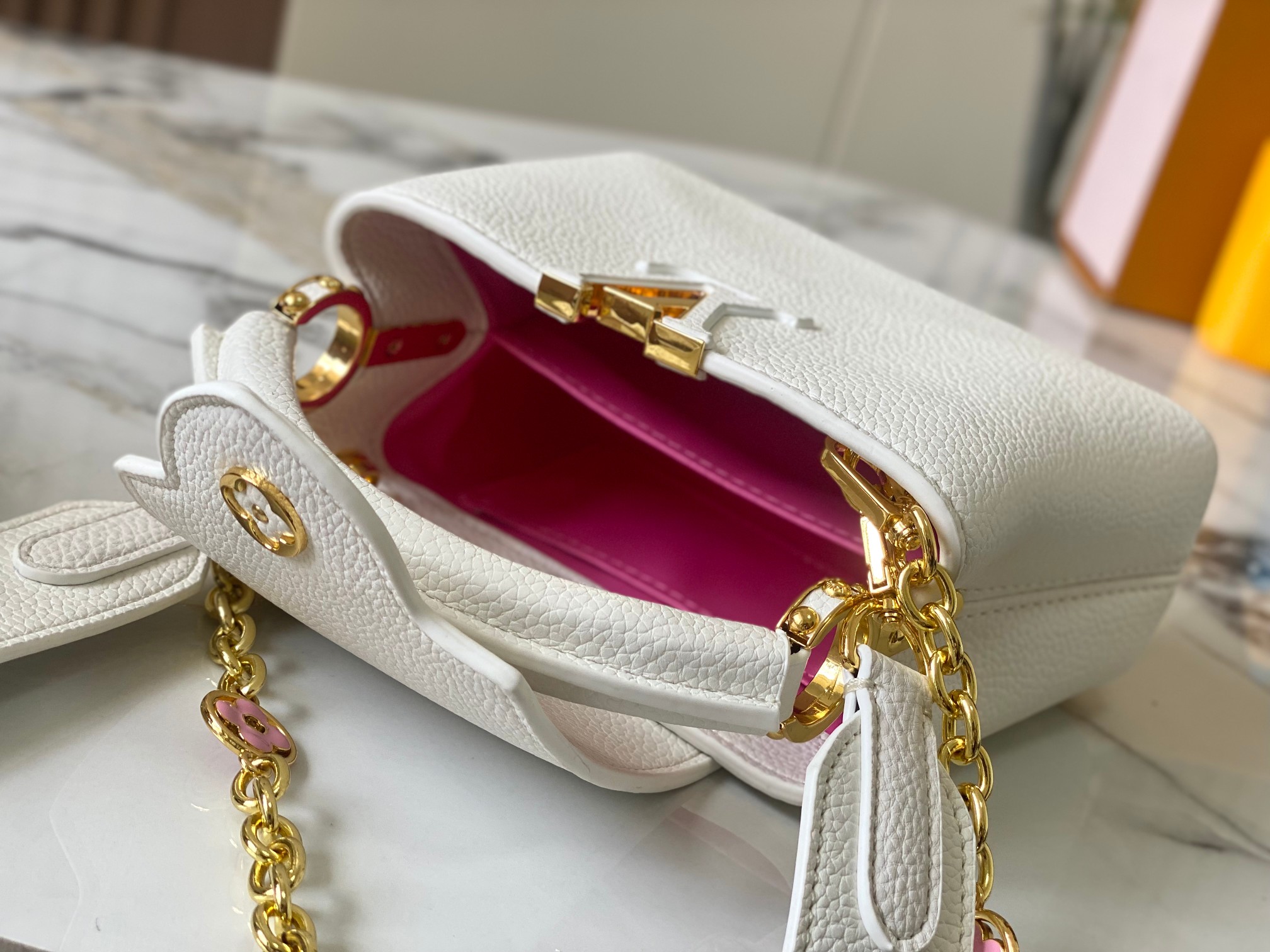 升级版 M20845白色花卉
本款 Cap-ucines 迷你手袋展现柔婉之美：Taurillon 皮革