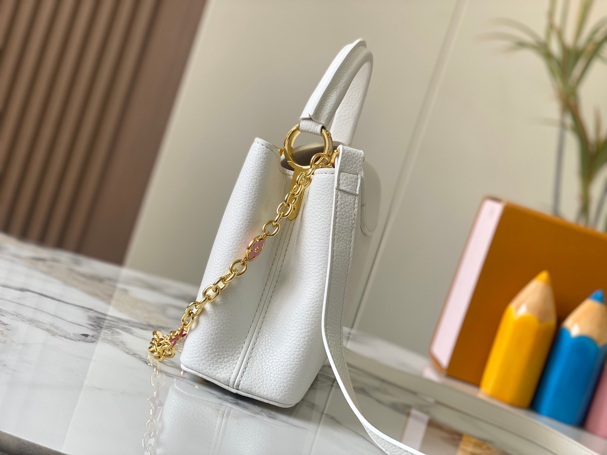 升级版 M20844白色花卉
本款 Cap-ucines BB 手袋取材 Taurillon 皮革，隐约