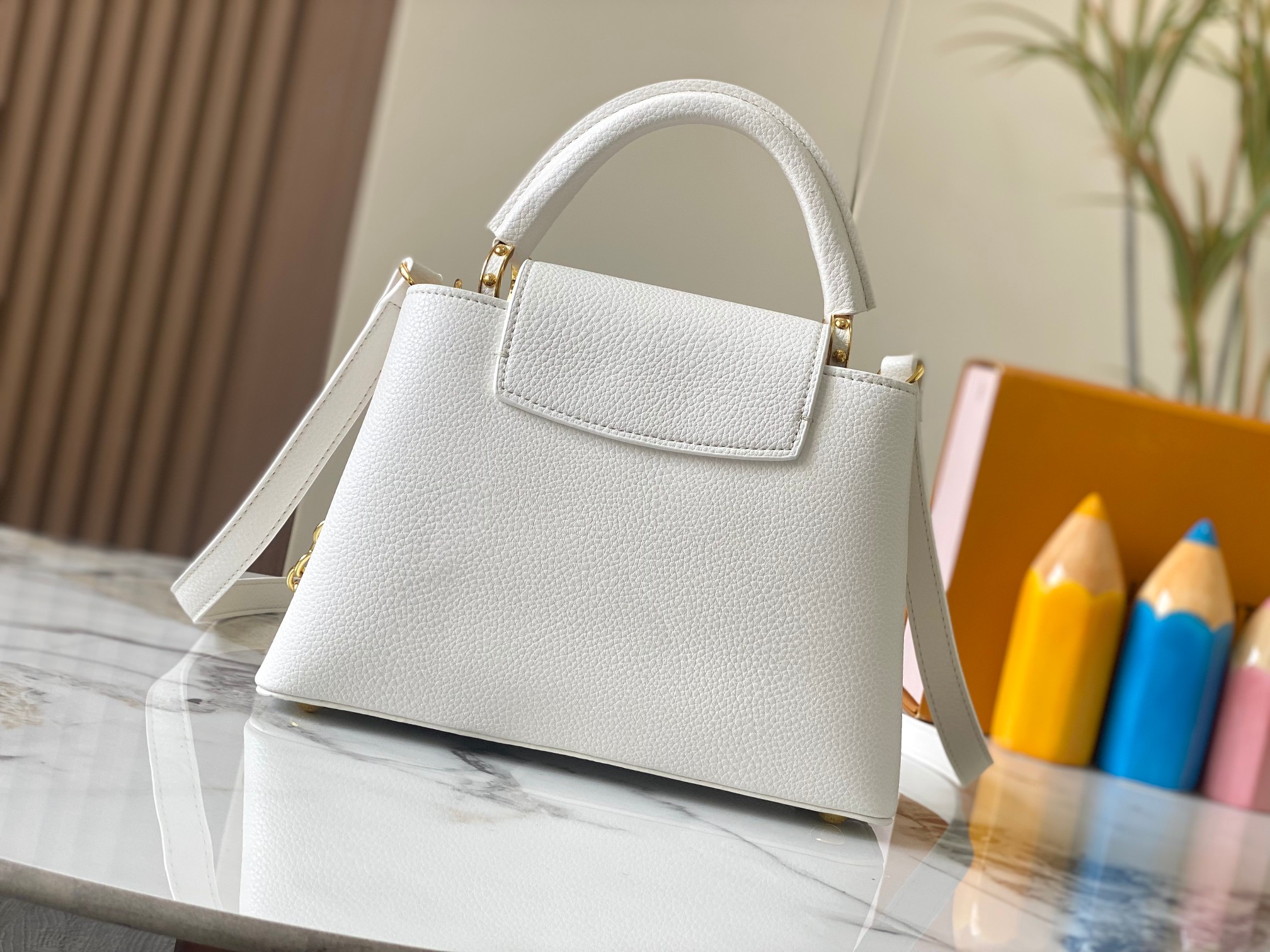 升级版 M20844白色花卉
本款 Cap-ucines BB 手袋取材 Taurillon 皮革，隐约