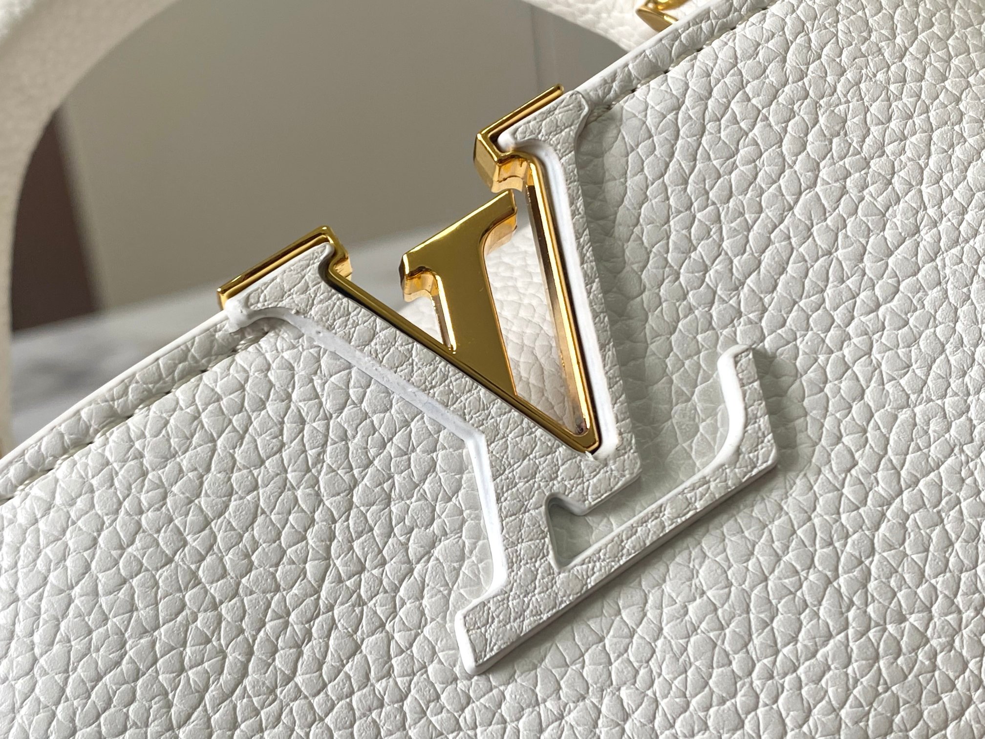 升级版 M20844白色花卉
本款 Cap-ucines BB 手袋取材 Taurillon 皮革，隐约