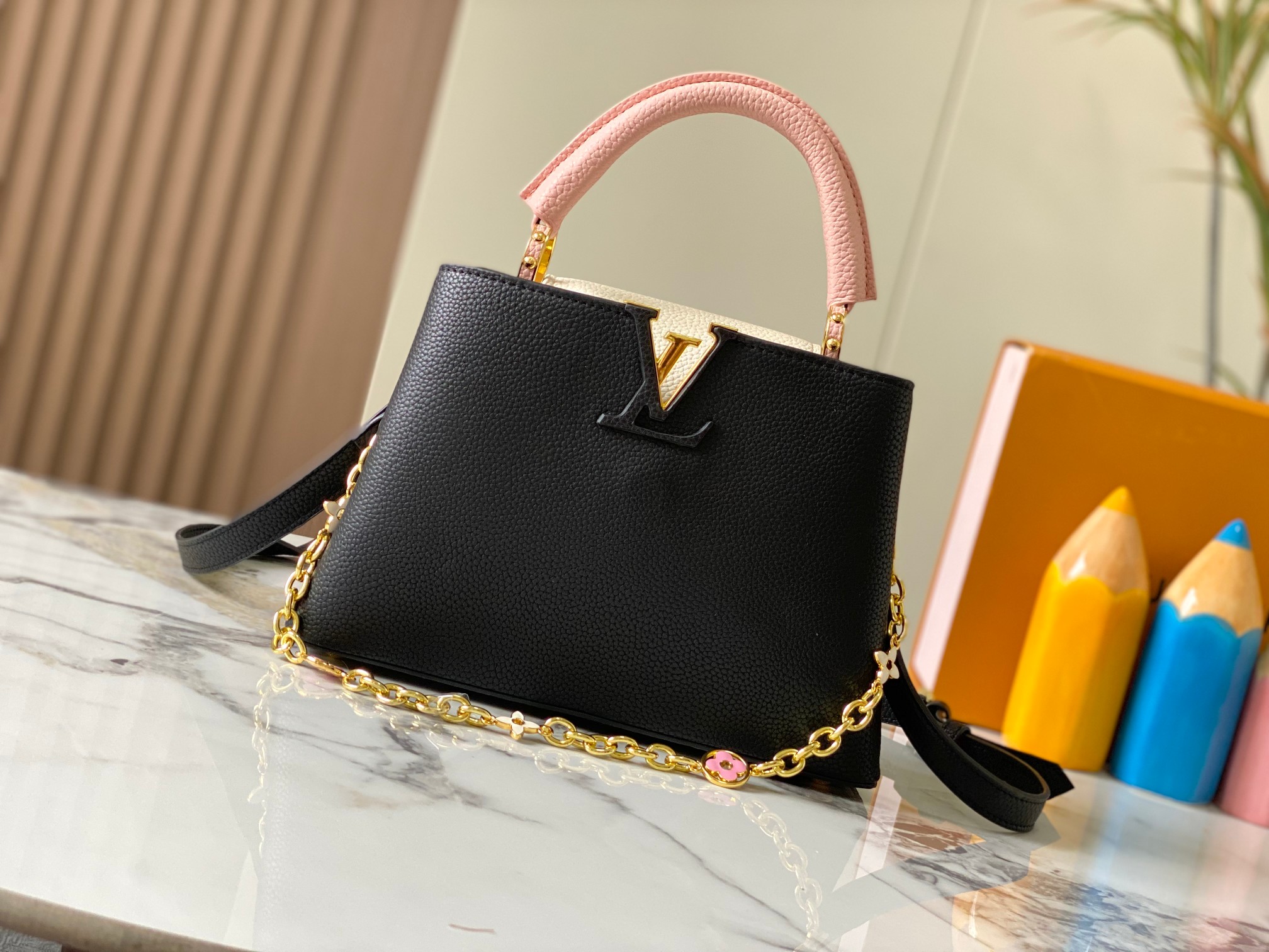 升级版 M20844黑粉花卉三拼
本款 Cap-ucines BB 手袋取材 Taurillon 皮革，