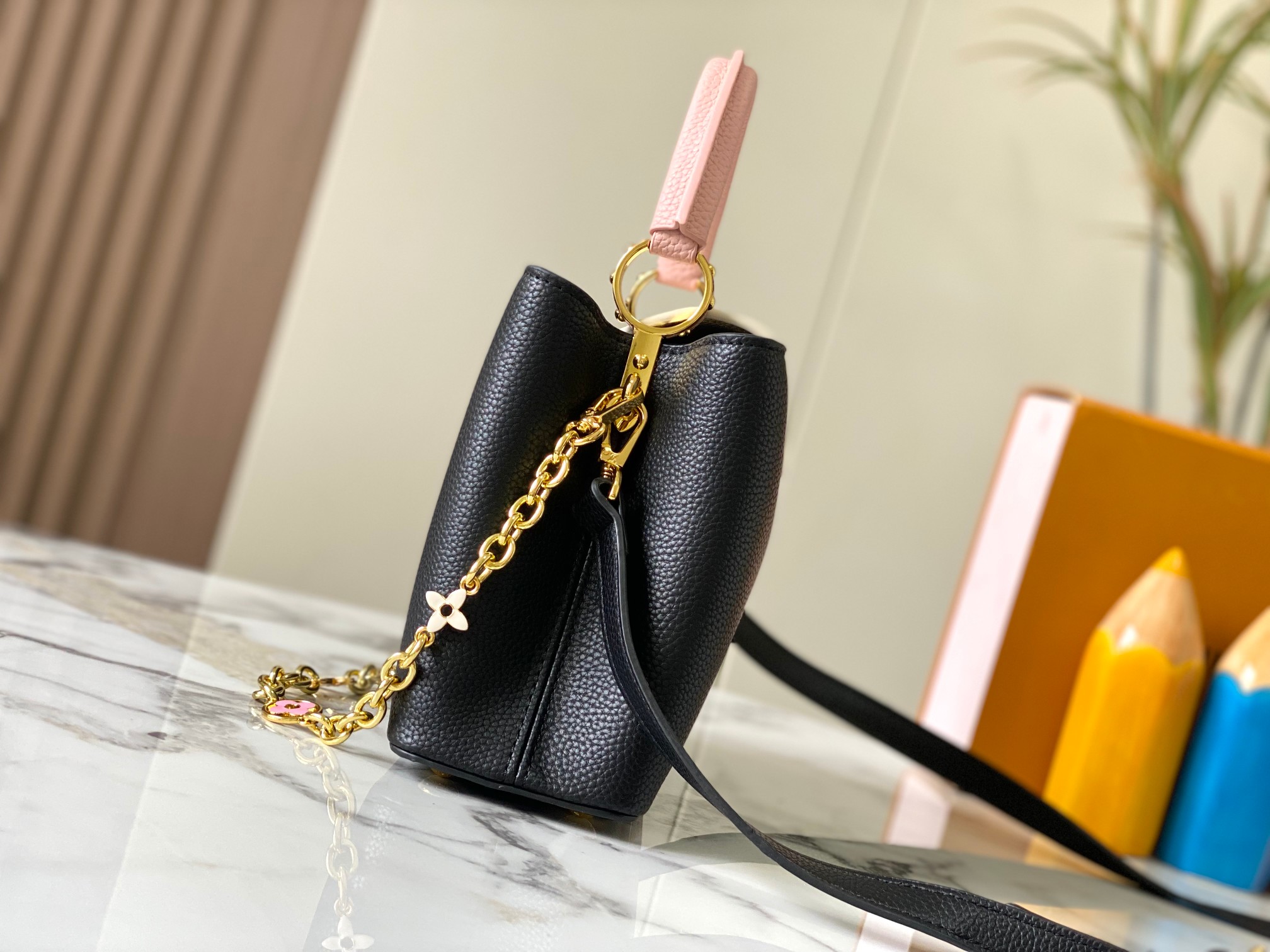 升级版 M20844黑粉花卉三拼
本款 Cap-ucines BB 手袋取材 Taurillon 皮革，