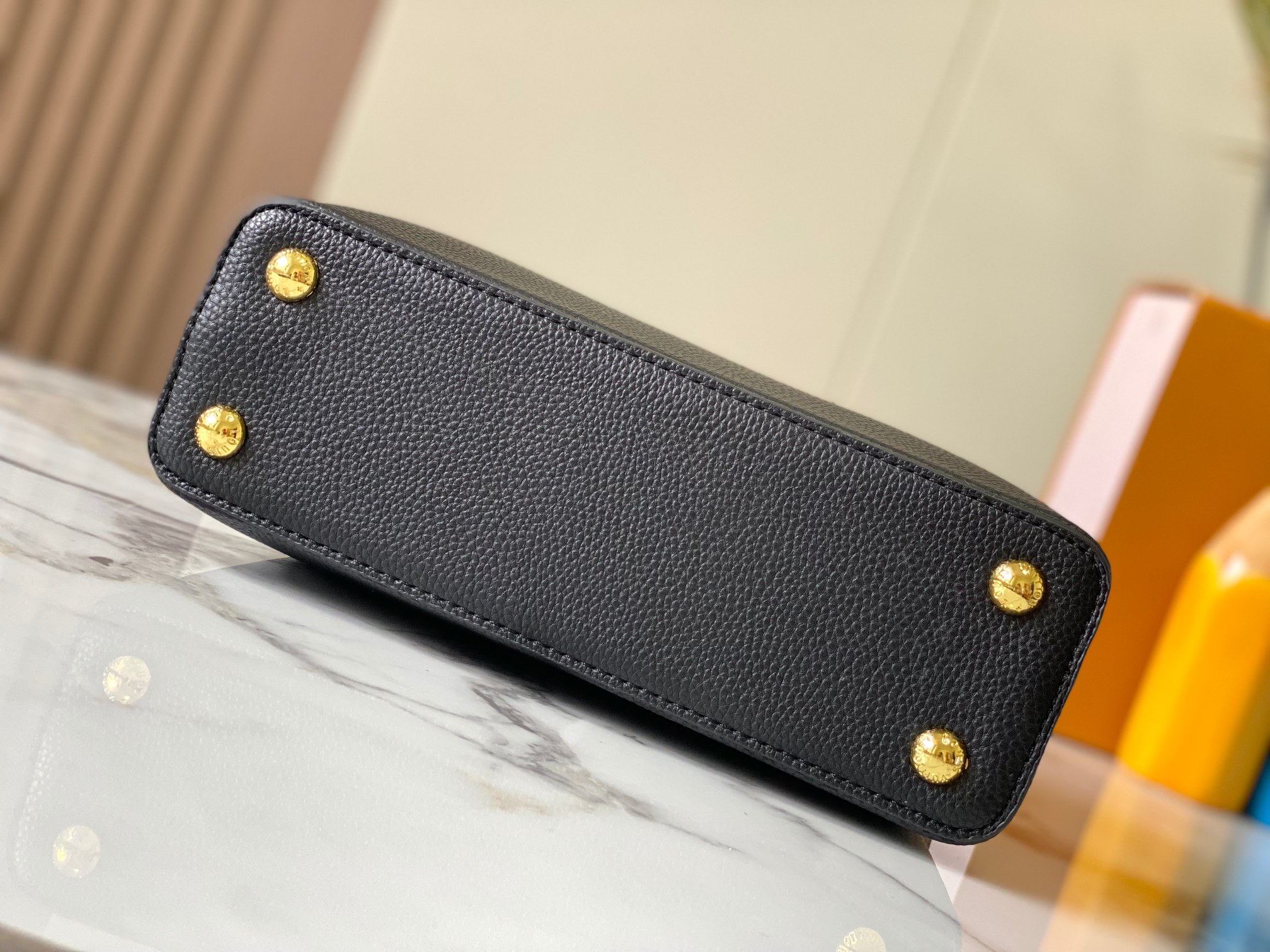 升级版 M20844黑粉花卉三拼
本款 Cap-ucines BB 手袋取材 Taurillon 皮革，