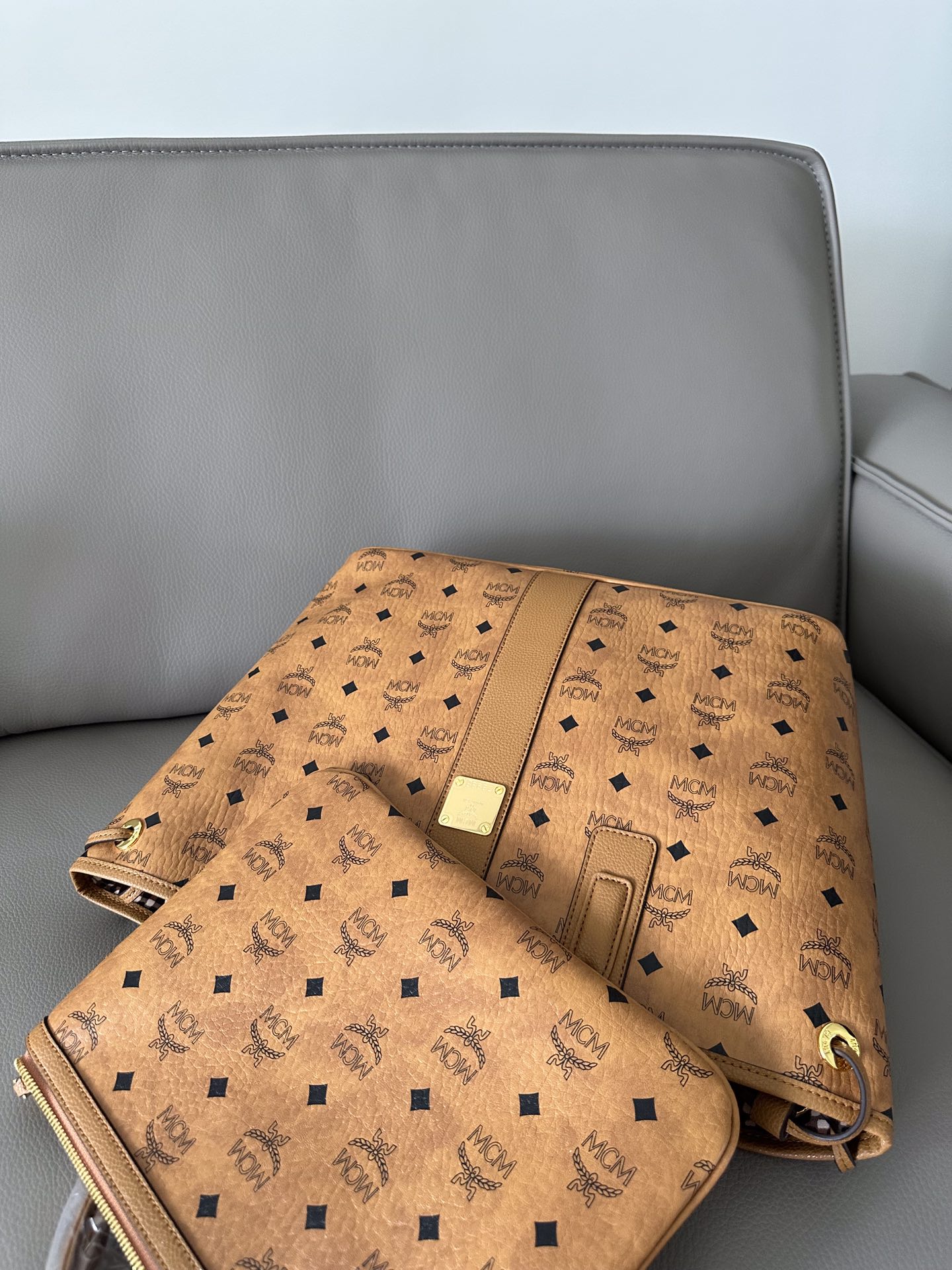 MCM 独家 可翻转至格纹印花衬里的一面使用 侧边抽绳可调节轮廓 并配有可拆卸内袋 顶部皮革双提手