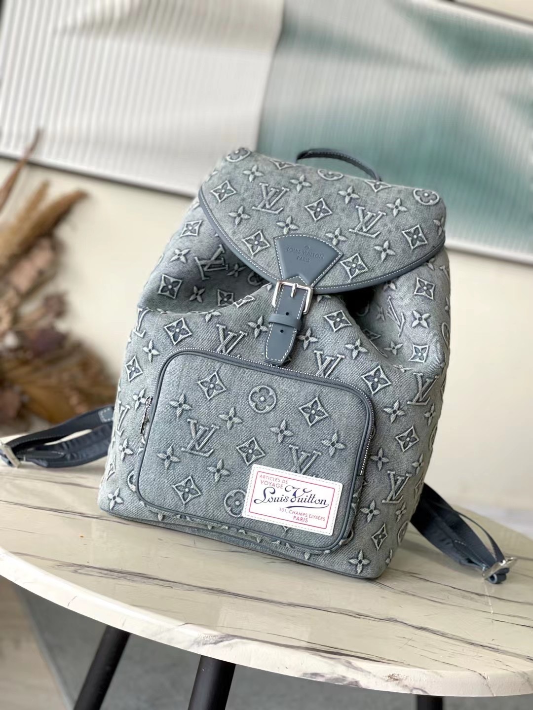 The latest Montsouris Backpack in faded denim, featuring an embossed - Bag