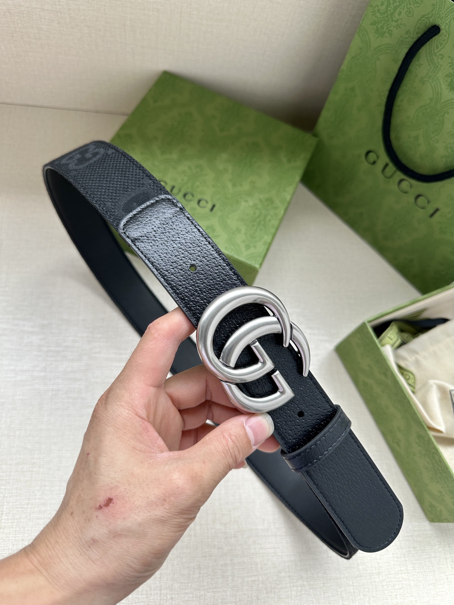 宽度4.0 GUCCI 标志性GG帆布以黑色焕新呈现，传承品牌本源。这款腰带饰有双G细节，钯金色调交织字