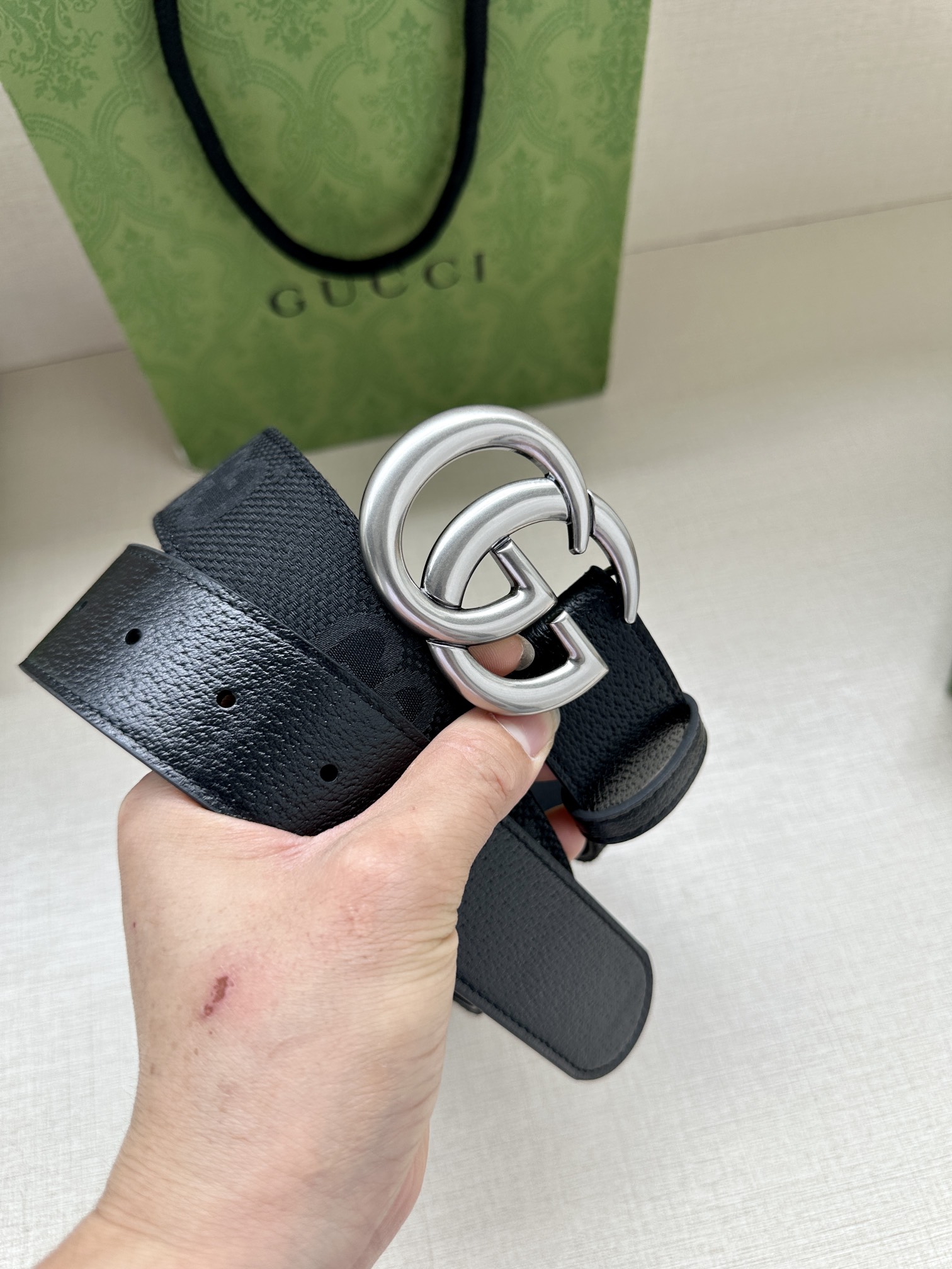 宽度4.0 GUCCI 标志性GG帆布以黑色焕新呈现，传承品牌本源。这款腰带饰有双G细节，钯金色调交织字