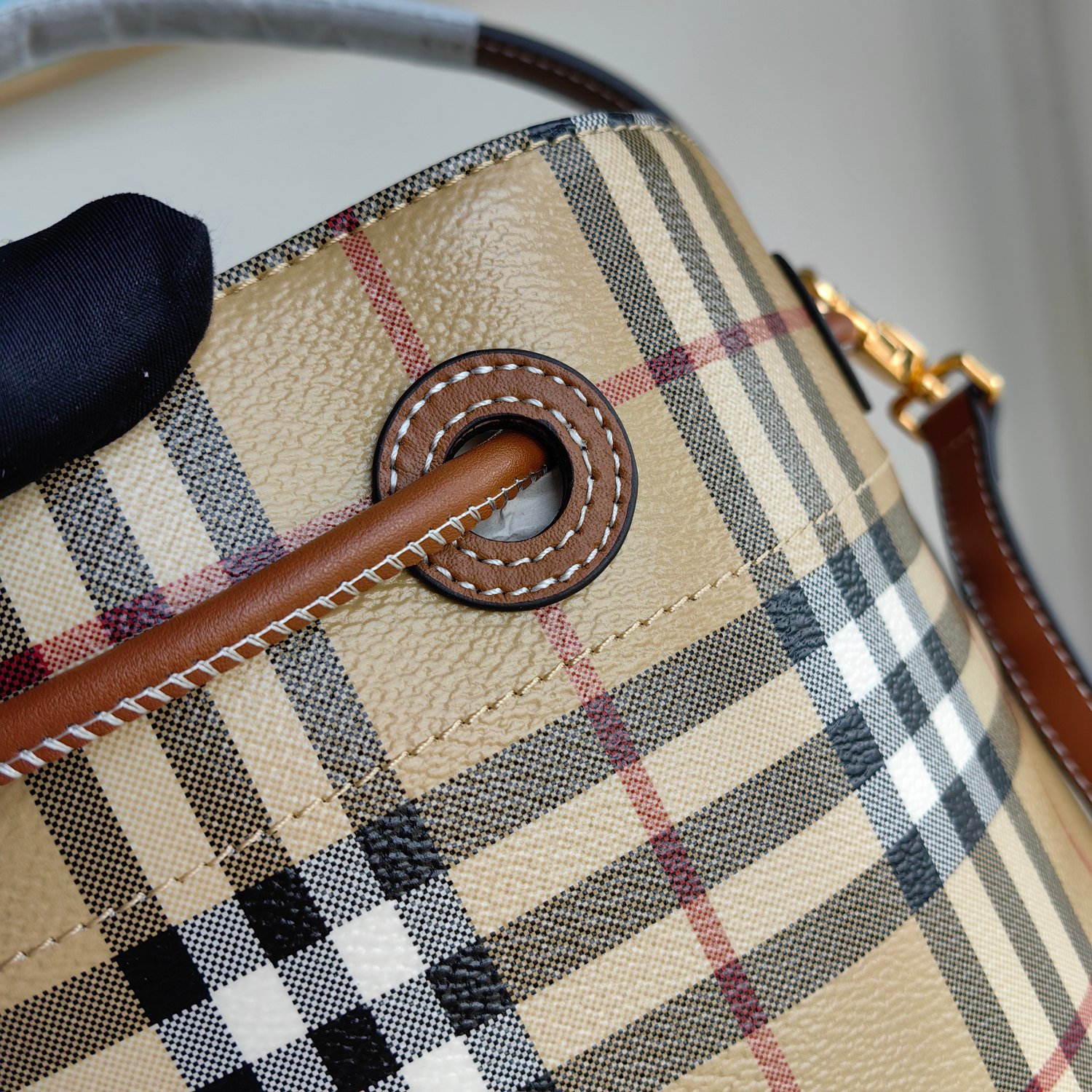 () B's small drawstring bucket bag, decorated with Burberry plaid, paired with Italian tanned leather edging and TB exclusive logo. 16 x 26 x 26cm. Detachable and adjustable diagonal strap. 1 inner pocket Adjustable drawstring opening and closing Hand drawn painted edges Glossy metal accessories photo 7