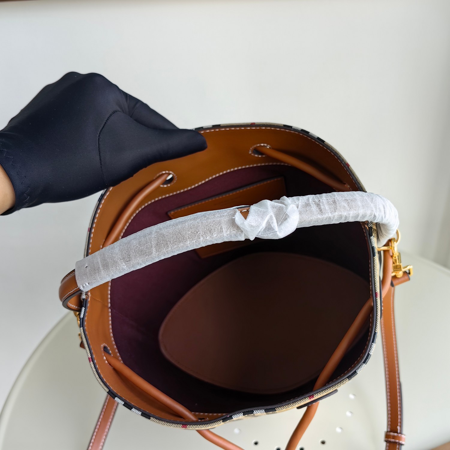 () B's small drawstring bucket bag, decorated with Burberry plaid, paired with Italian tanned leather edging and TB exclusive logo. 16 x 26 x 26cm. Detachable and adjustable diagonal strap. 1 inner pocket Adjustable drawstring opening and closing Hand drawn painted edges Glossy metal accessories photo 9