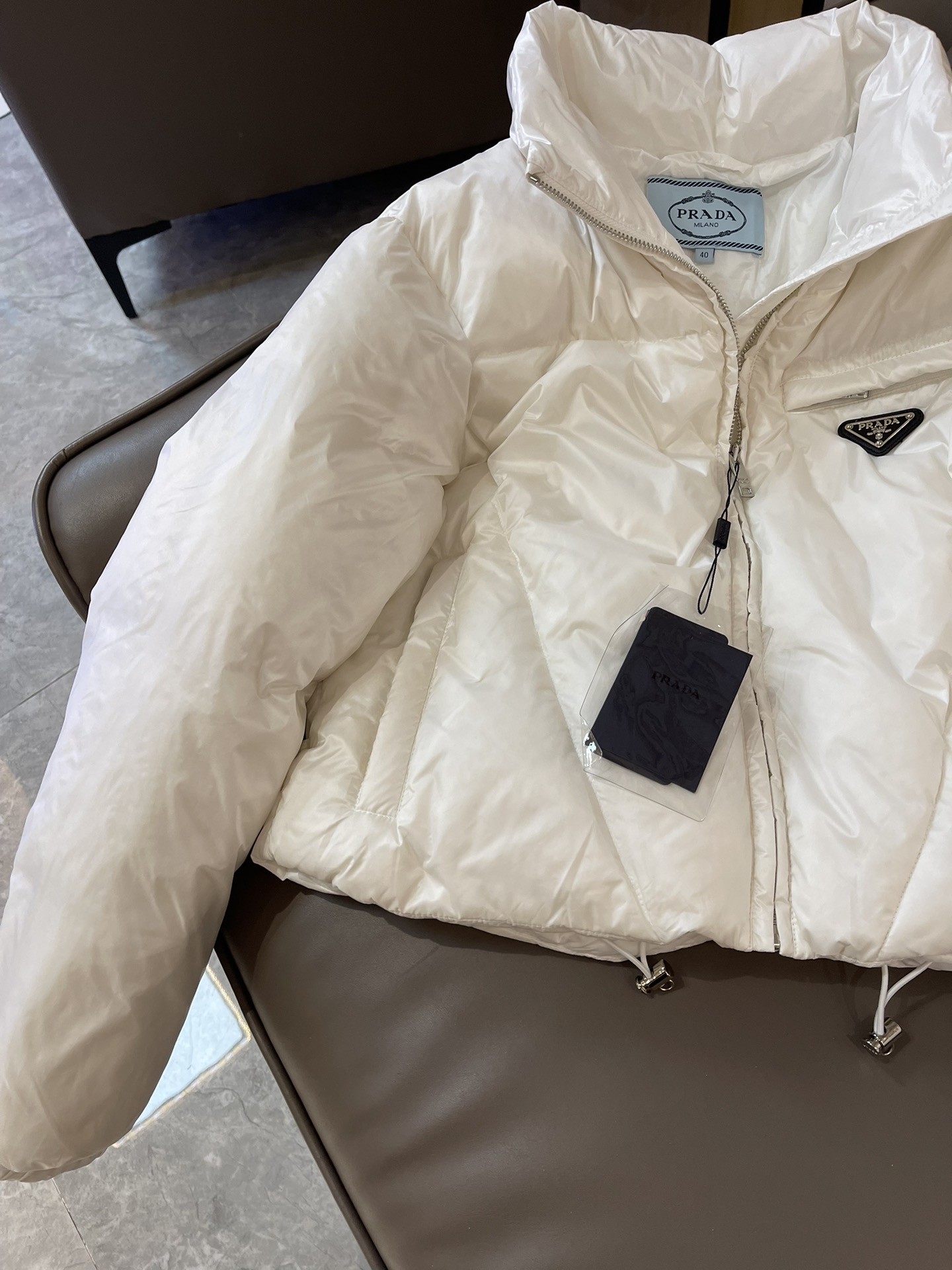 Prada triangle logo 90% white goose down short jacket in black, white, brown. Sizes 38-44.-Big cat