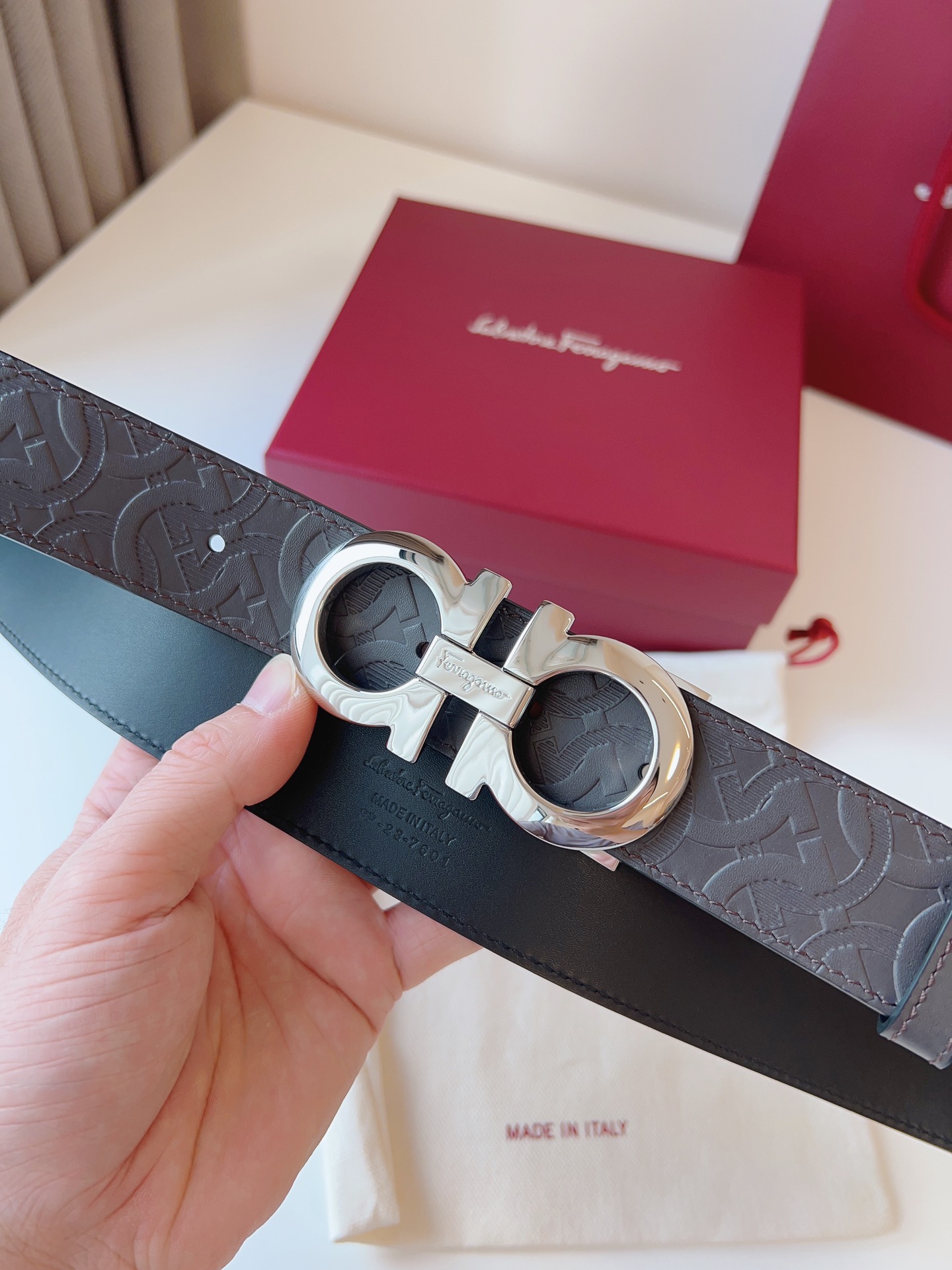 菲拉家 男士双面用质感真皮腰带，经典款，高端精品系列的标志性单品，兼具奢华工艺与实用设计，非常适合追求品质与细节的男性用户。
【高端精品品质】精选进口头层小牛皮，天然粒纹皮革双面设计，细腻耐磨，厚度适中，宽度3.4CM，适配现代绅士着装需求。
【匠心工艺】
可调式双面佩戴 ：一带两用，轻松切换商务与休闲风格；长度可自由裁剪，满足个性化腰围需求。
标志性金属细节 ：同色调G-i扣饰搭配撞色衬里，8字镂空夹扣象征“发财”寓意，精致真空电镀工艺，抗磨耐用不褪色。
质感穿搭点睛 ：哑光皮质与金属光泽碰撞，低调诠释都市摩登格调，提升整体造型高级感。
【专属包装】附赠全套礼盒包装，自用赠礼两相宜。
经典永续，绅士衣橱必备之选。160