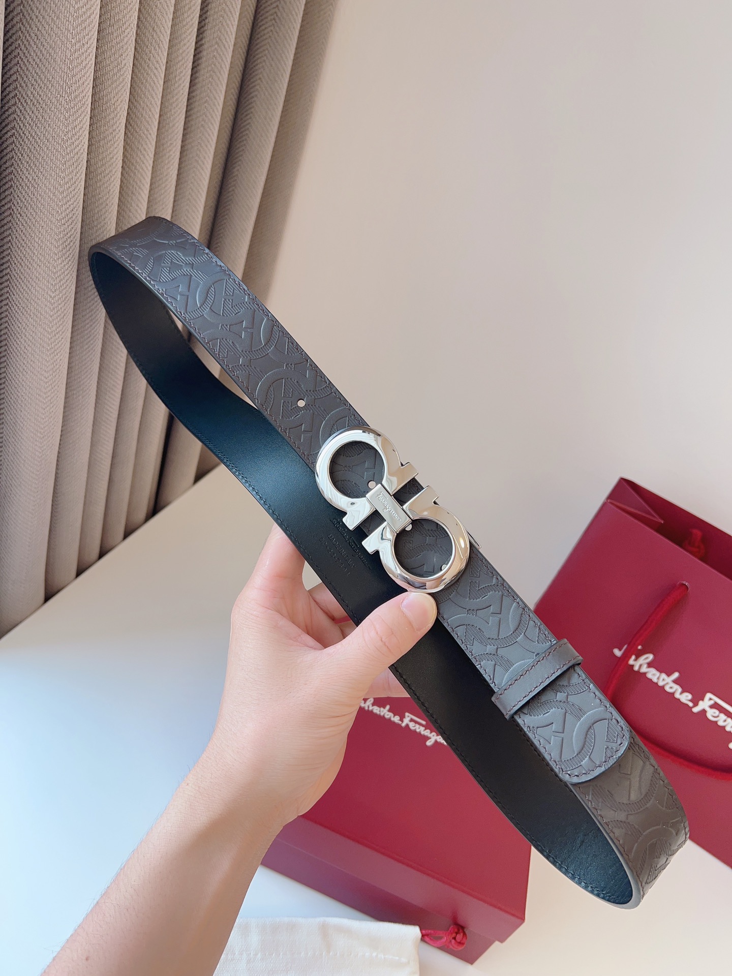 菲拉家 男士双面用质感真皮腰带，经典款，高端精品系列的标志性单品，兼具奢华工艺与实用设计，非常适合追求品质与细节的男性用户。
【高端精品品质】精选进口头层小牛皮，天然粒纹皮革双面设计，细腻耐磨，厚度适中，宽度3.4CM，适配现代绅士着装需求。
【匠心工艺】
可调式双面佩戴 ：一带两用，轻松切换商务与休闲风格；长度可自由裁剪，满足个性化腰围需求。
标志性金属细节 ：同色调G-i扣饰搭配撞色衬里，8字镂空夹扣象征“发财”寓意，精致真空电镀工艺，抗磨耐用不褪色。
质感穿搭点睛 ：哑光皮质与金属光泽碰撞，低调诠释都市摩登格调，提升整体造型高级感。
【专属包装】附赠全套礼盒包装，自用赠礼两相宜。
经典永续，绅士衣橱必备之选。160