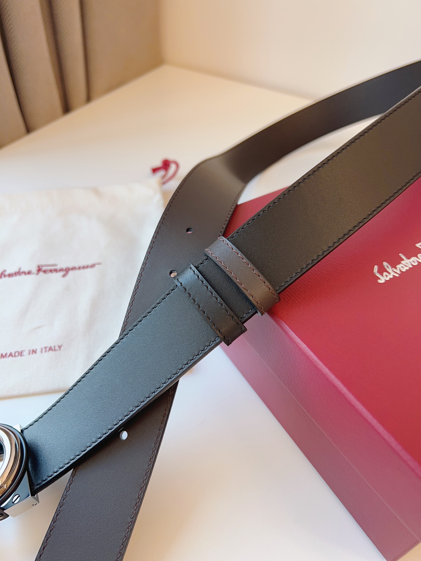 菲拉家 男士双面用质感真皮腰带，经典款，高端精品系列的标志性单品，兼具奢华工艺与实用设计，非常适合追求品质与细节的男性用户。
【高端精品品质】精选进口头层小牛皮，天然粒纹皮革双面设计，细腻耐磨，厚度适中，宽度3.4CM，适配现代绅士着装需求。
【匠心工艺】
可调式双面佩戴 ：一带两用，轻松切换商务与休闲风格；长度可自由裁剪，满足个性化腰围需求。
标志性金属细节 ：同色调G-i扣饰搭配撞色衬里，8字镂空夹扣象征“发财”寓意，精致真空电镀工艺，抗磨耐用不褪色。
质感穿搭点睛 ：哑光皮质与金属光泽碰撞，低调诠释都市摩登格调，提升整体造型高级感。
【专属包装】附赠全套礼盒包装，自用赠礼两相宜。
经典永续，绅士衣橱必备之选。160