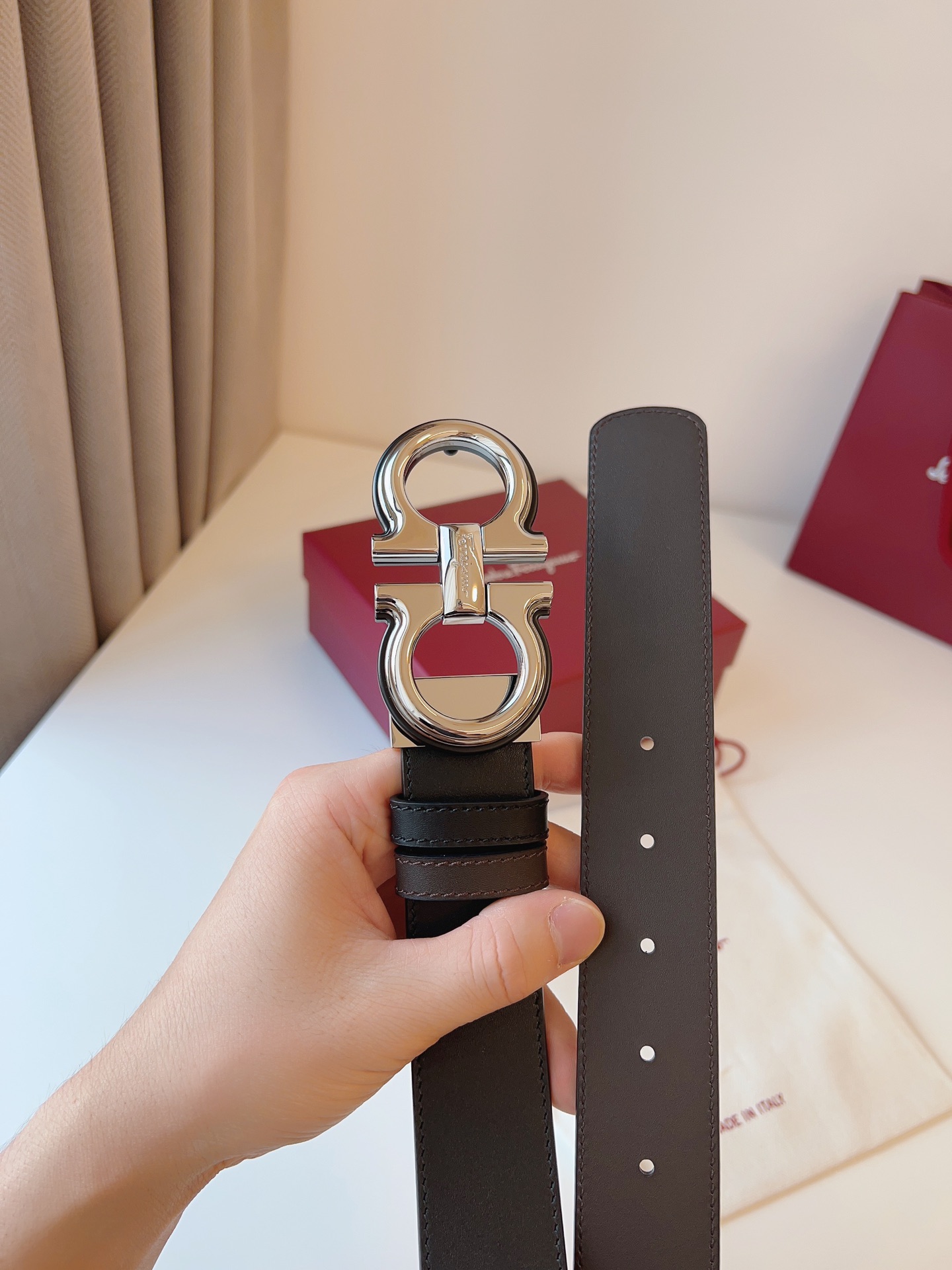 菲拉家 男士双面用质感真皮腰带，经典款，高端精品系列的标志性单品，兼具奢华工艺与实用设计，非常适合追求品质与细节的男性用户。
【高端精品品质】精选进口头层小牛皮，天然粒纹皮革双面设计，细腻耐磨，厚度适中，宽度3.4CM，适配现代绅士着装需求。
【匠心工艺】
可调式双面佩戴 ：一带两用，轻松切换商务与休闲风格；长度可自由裁剪，满足个性化腰围需求。
标志性金属细节 ：同色调G-i扣饰搭配撞色衬里，8字镂空夹扣象征“发财”寓意，精致真空电镀工艺，抗磨耐用不褪色。
质感穿搭点睛 ：哑光皮质与金属光泽碰撞，低调诠释都市摩登格调，提升整体造型高级感。
【专属包装】附赠全套礼盒包装，自用赠礼两相宜。
经典永续，绅士衣橱必备之选。160