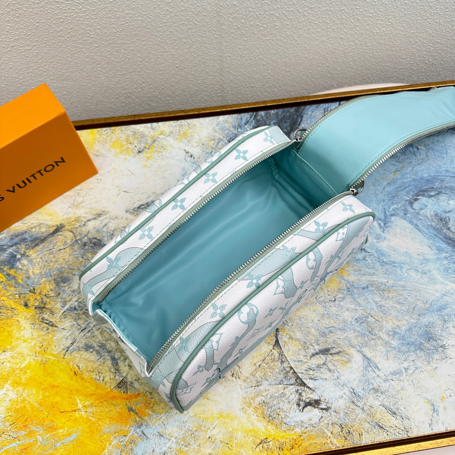 Close up of the leather wash bag, showing the brand logo.