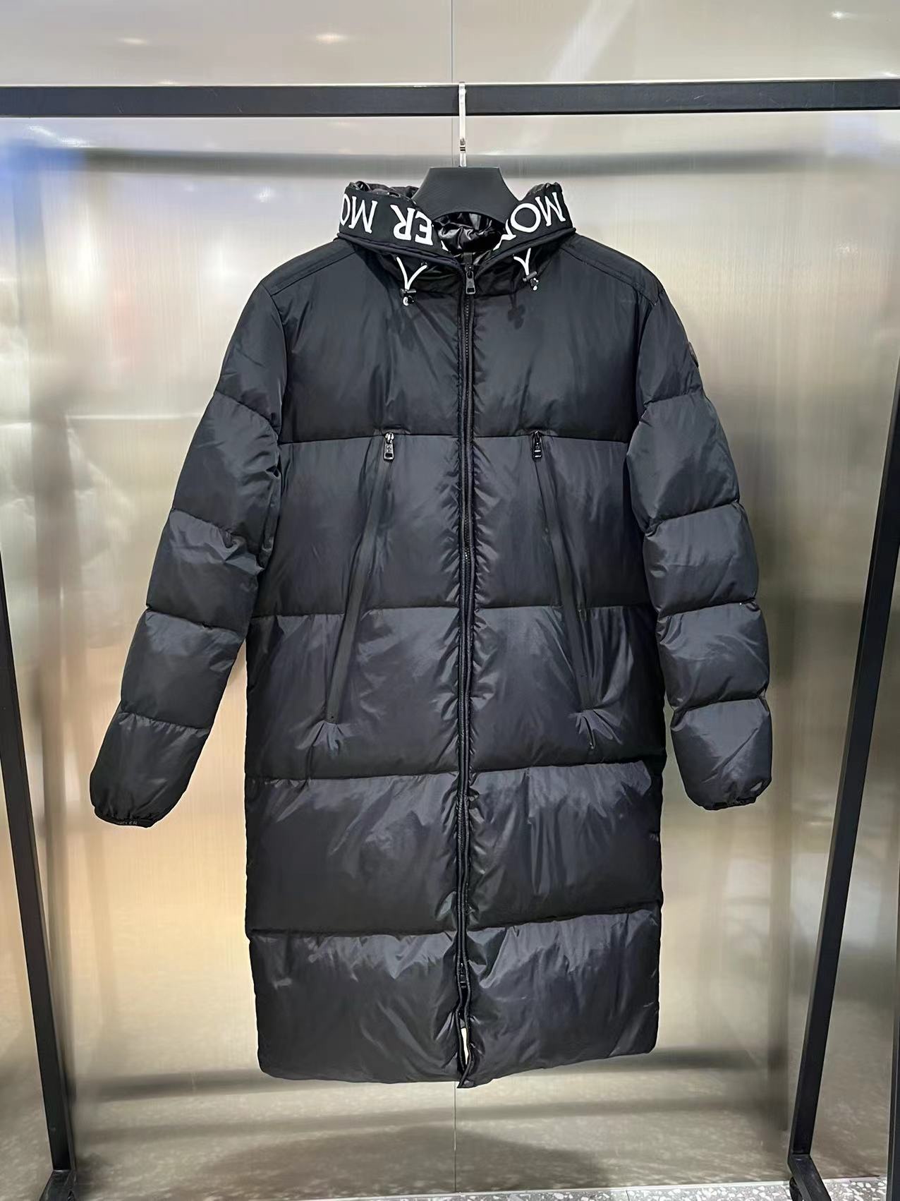 Moncler long jacket with 80s style, waterproof and insulated. Features embroidered logo, hooded design, adjustable hem. Colors: black, white. Sizes: 1-5.-Big cat