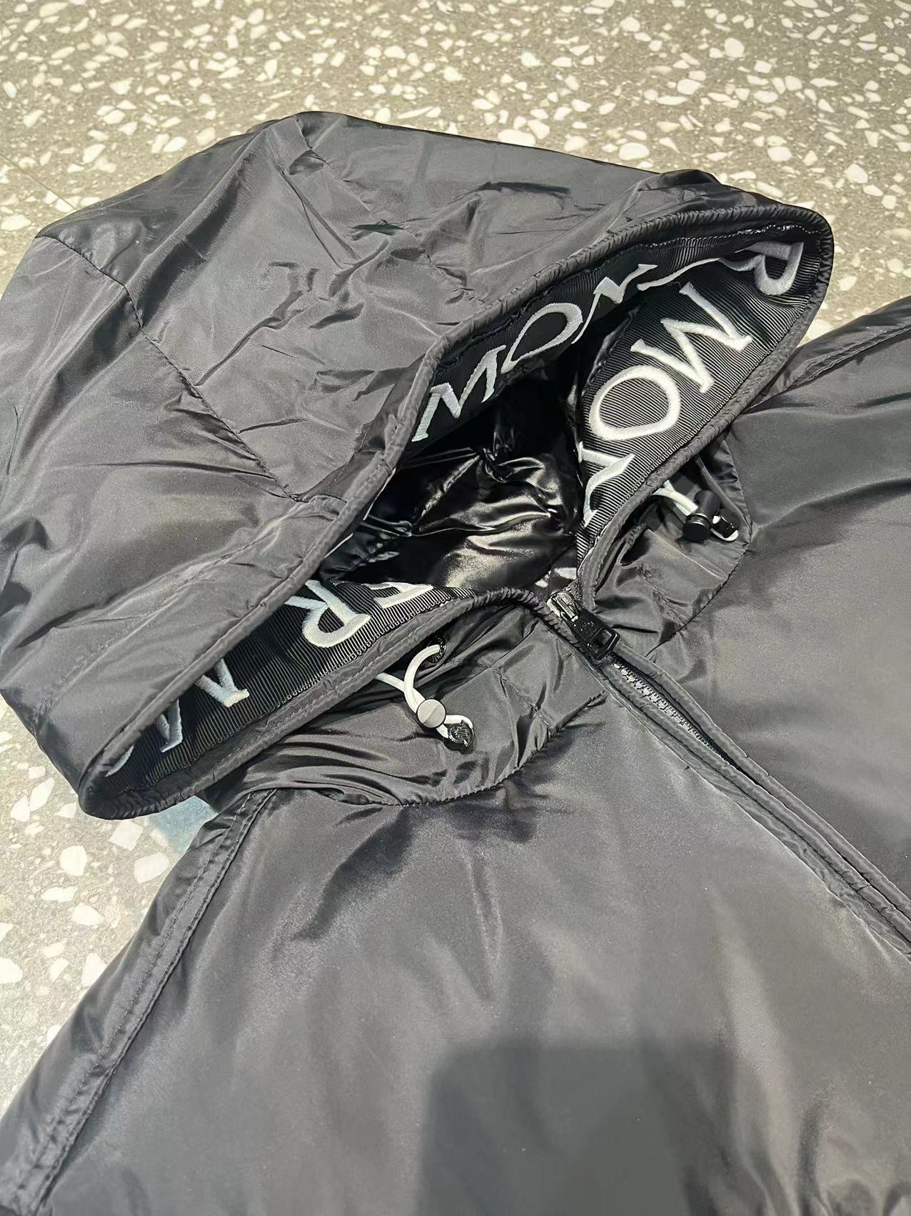 Moncler long jacket with 80s style, waterproof and insulated. Features embroidered logo, hooded design, adjustable hem. Colors: black, white. Sizes: 1-5.-Big cat