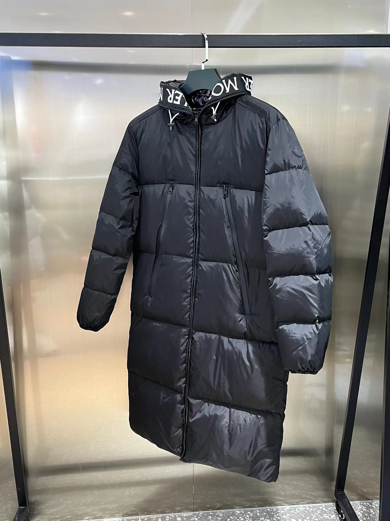 Moncler long jacket with 80s style, waterproof and insulated. Features embroidered logo, hooded design, adjustable hem. Colors: black, white. Sizes: 1-5.-Big cat