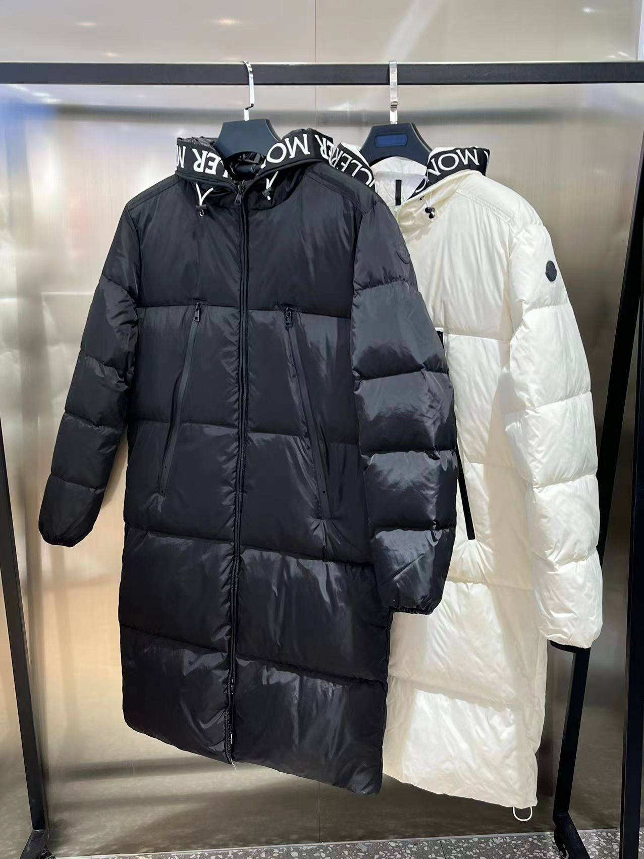 Moncler long jacket with 80s inspiration. Waterproof, insulated, embroidered logo. Hooded nylon quilted design. Colors: black, white. Sizes available.-Big cat