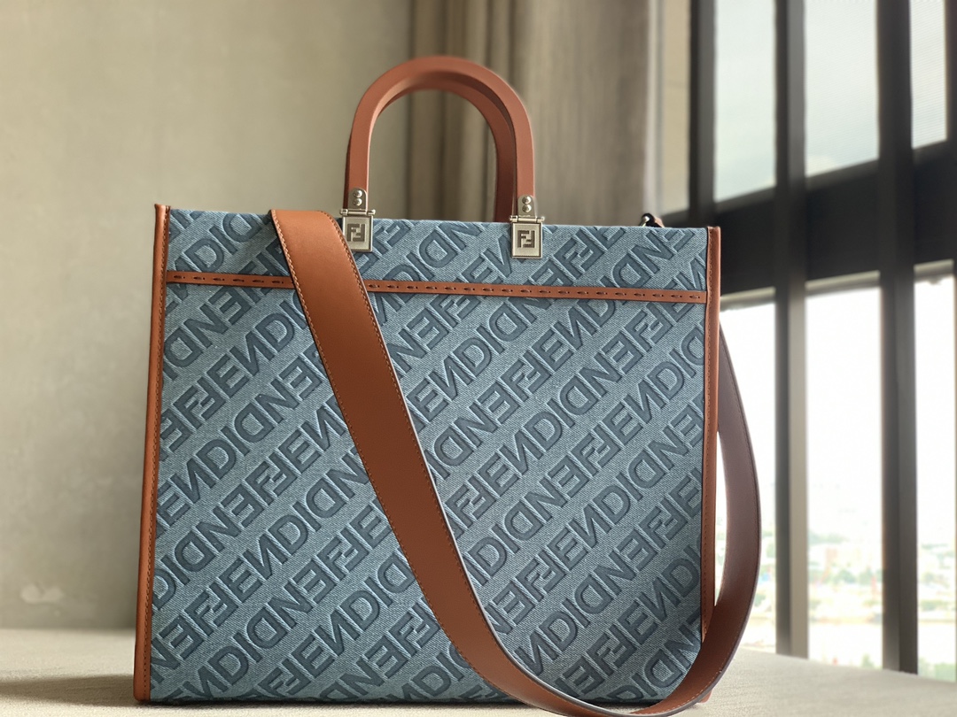 fendi Sunshine medium shopper bag in light blue denim with FENDI Mirror pattern all over. Brown solid leather handle with FENDI ROMA signature. F