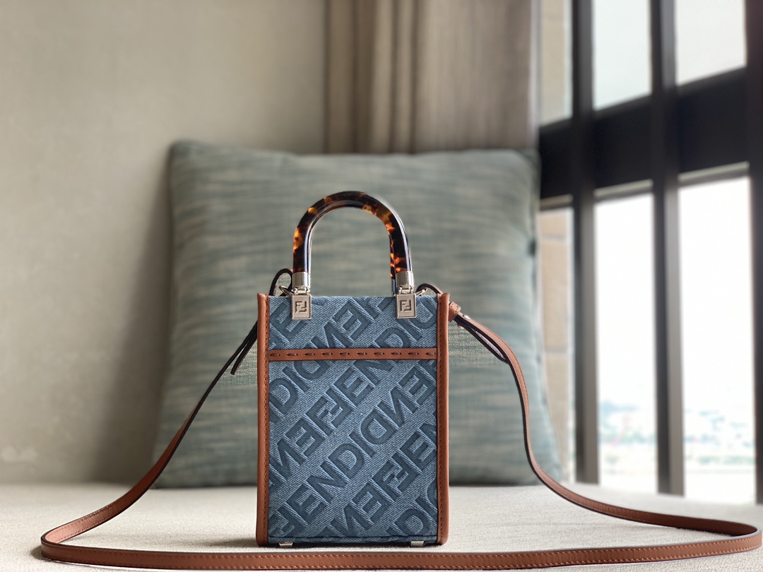 Officially on sale is the Fendi Sunshine mini tote bag, made of light blue denim and decorated with the FENDI Mirror pattern throughout. Brown co