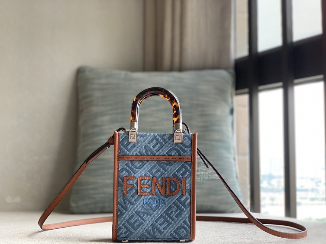 Officially on sale is the Fendi Sunshine mini tote bag, made of light blue denim and decorated with the FENDI Mirror pattern throughout. Brown co