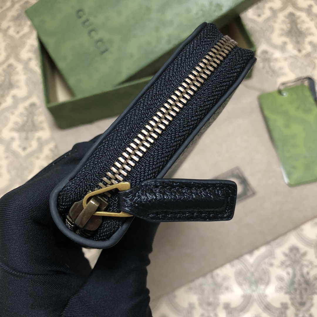 此款全拉链式钱包，配以醒目的标志性双 G 金属配件。采用热压小牛皮制作，以获得野猪猪皮效果，营造织纹外观