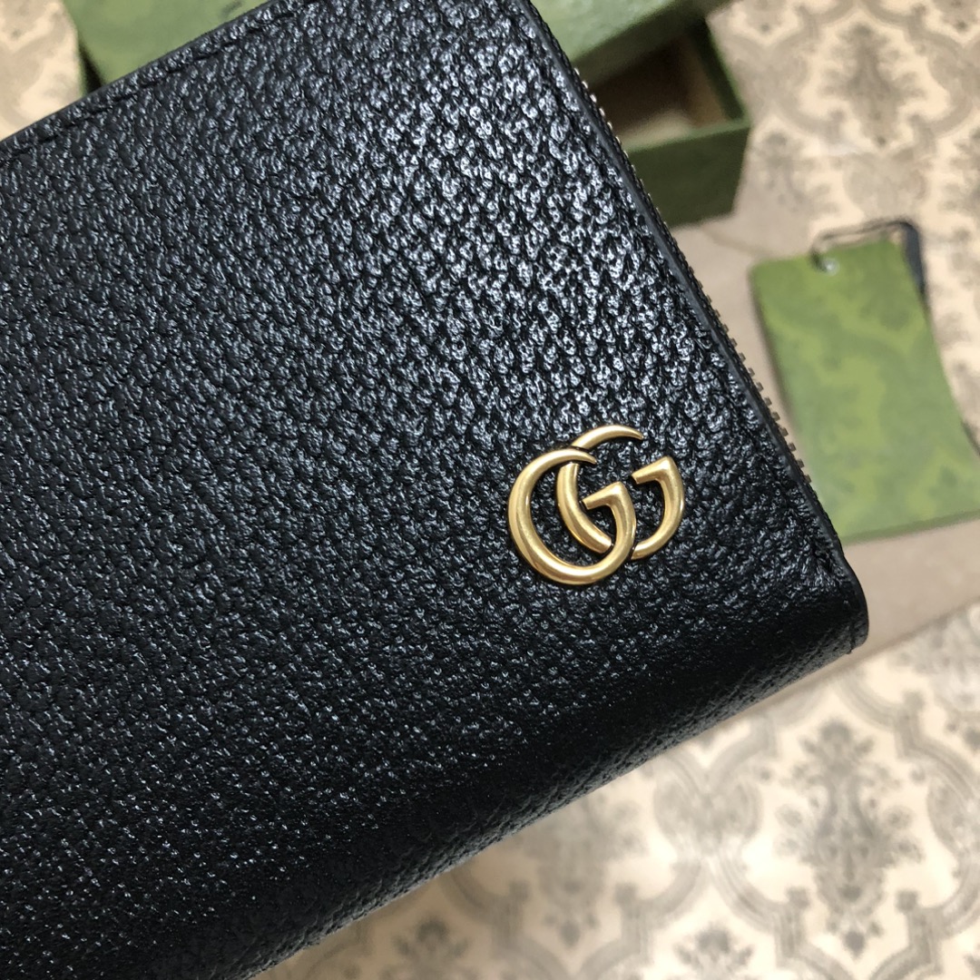 此款全拉链式钱包，配以醒目的标志性双 G 金属配件。采用热压小牛皮制作，以获得野猪猪皮效果，营造织纹外观