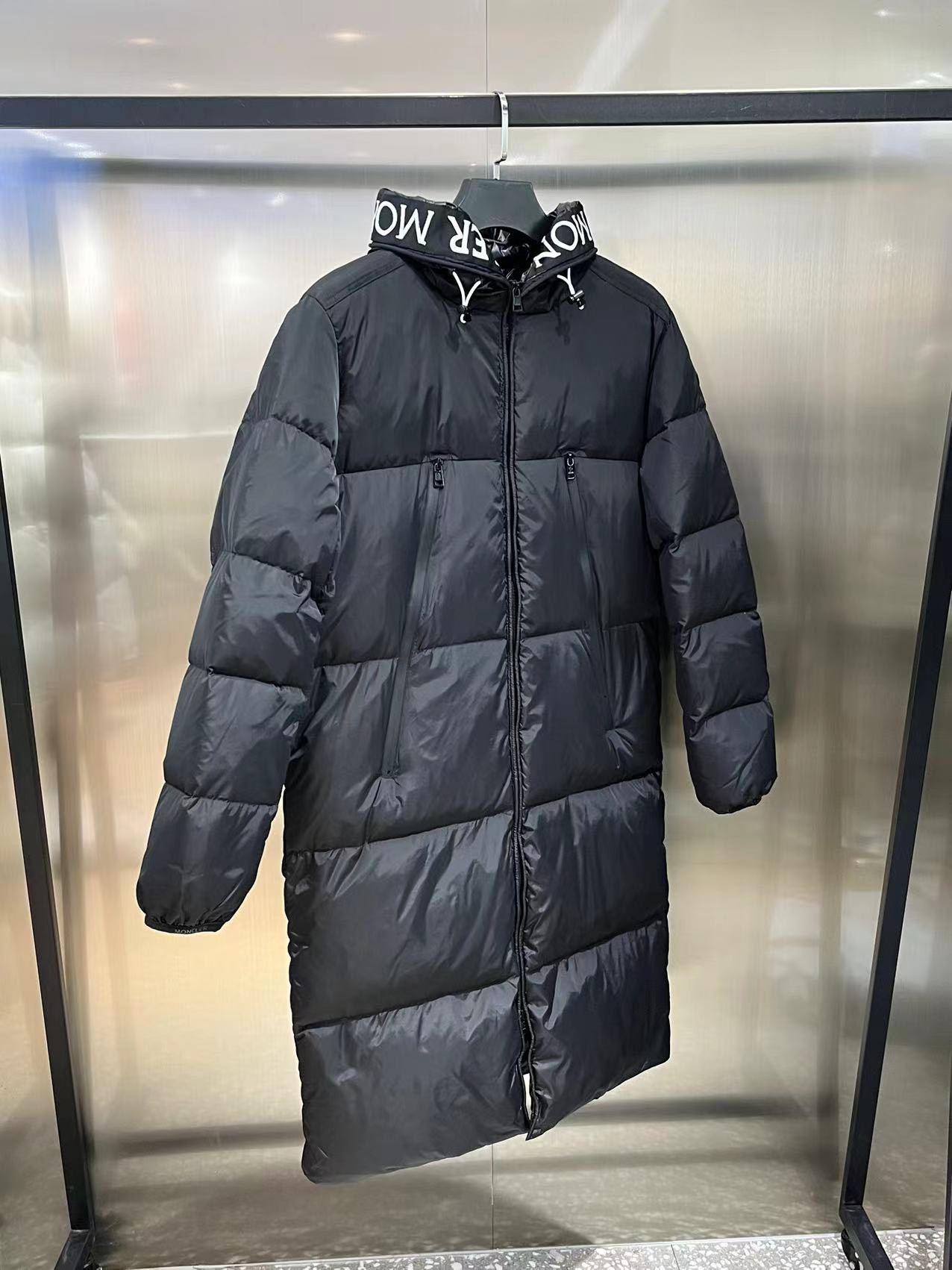 Moncler long jacket with 80s inspiration. Waterproof, insulated, embroidered logo. Hooded nylon quilted design. Colors: black, white. Sizes available.-Big cat