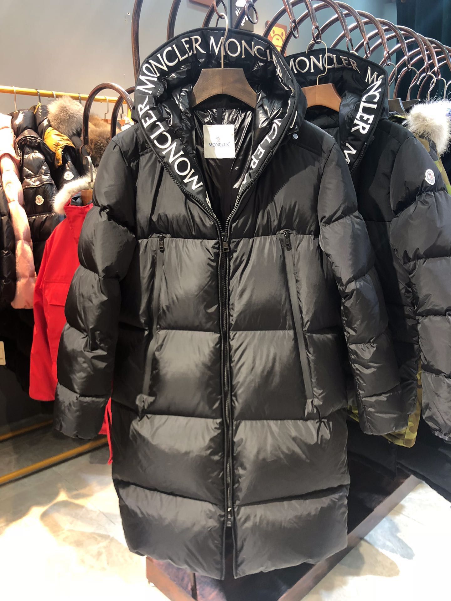 Moncler long jacket with 80s style, waterproof and insulated. Embroidered logo, hooded, quilted nylon. Colors: black, white. Sizes: 1-5.-Big cat