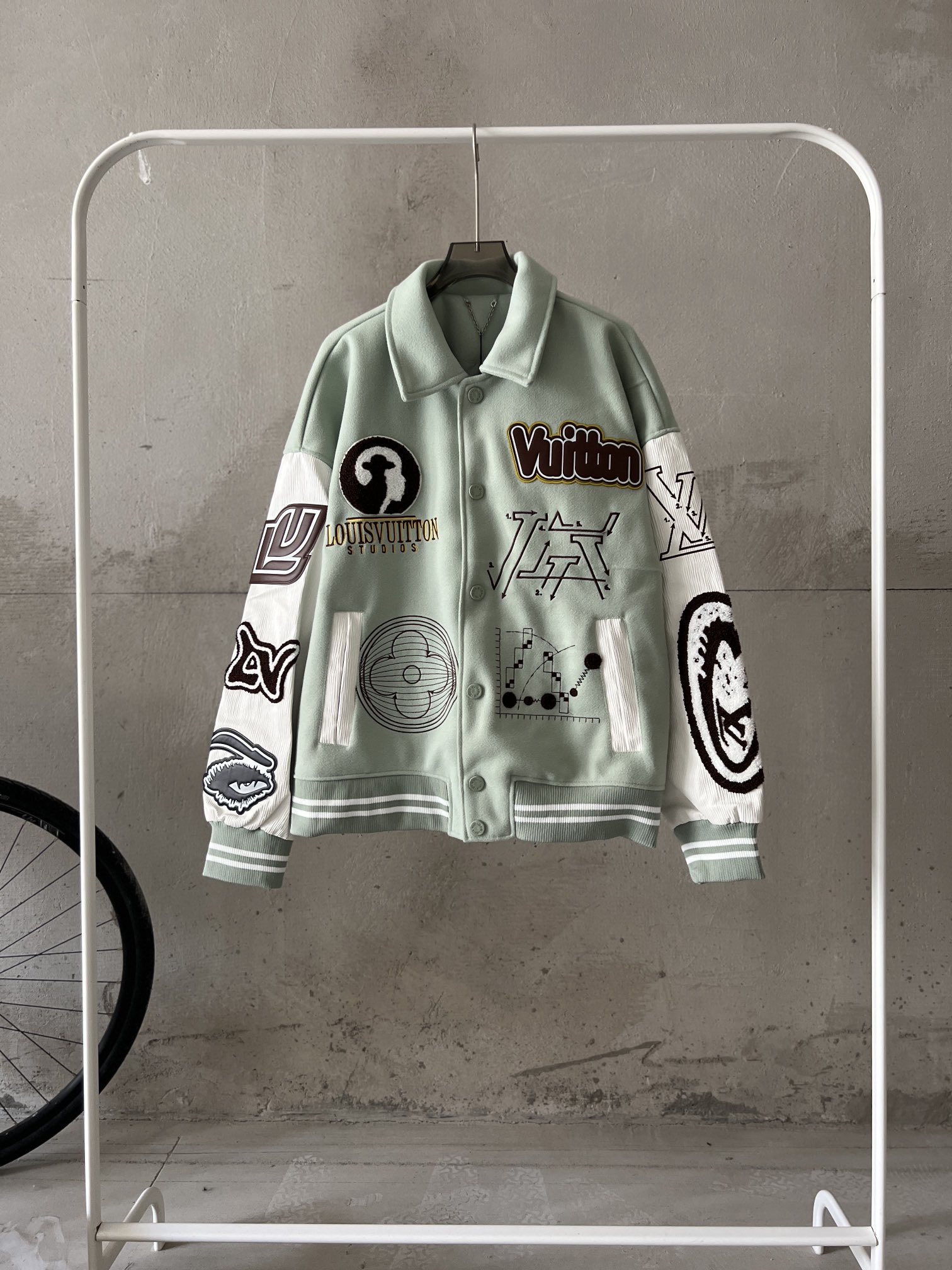 💰195
路易威登1v恶魔之眼毛巾绣加几何平绣棒球服外套夹克
白敬亭同款棒球服 穿上身你就走在时尚的最前沿
秋天谁能抵挡住棒球服的诱惑，既凹造型，又不显臃肿，搭配帽衫，温度可控。这款恶魔之眼一经面世，就受到各路粉丝追捧，不得不说上身是真的很好看。就是做起来有些繁琐，各处都要定制。
先说辅料上，袖子上面的皮革，纽扣和衣领出的五金等等这些都需要开模定制。每一粒纽扣都有铭文logo，而且纽扣外边缘是不规则的，和大身面料还要无色差，所以通货纽扣是没办法替代的。这款大身还有多处刺绣，而且多为毛巾绣，要先把图案袖在毛詹上，再用激光雕刻出来，进而才能上机台进行固定拼缝，光刺绣这块涉及的工艺就有4种。
大身面料，由羊毛、天然丝、氨纶和其他绒质混纺而成，上手有质感，上身却不显的压坠，也能更好的维持廓型。下摆螺纹和大身同色无差，也都是同缸定染。
说的多不如上手一件，天渐寒，早晚常备。
尺码：M L XL XXL
M肩宽60胸围120衣长64袖长63 
L肩宽62胸围124衣长66袖长64