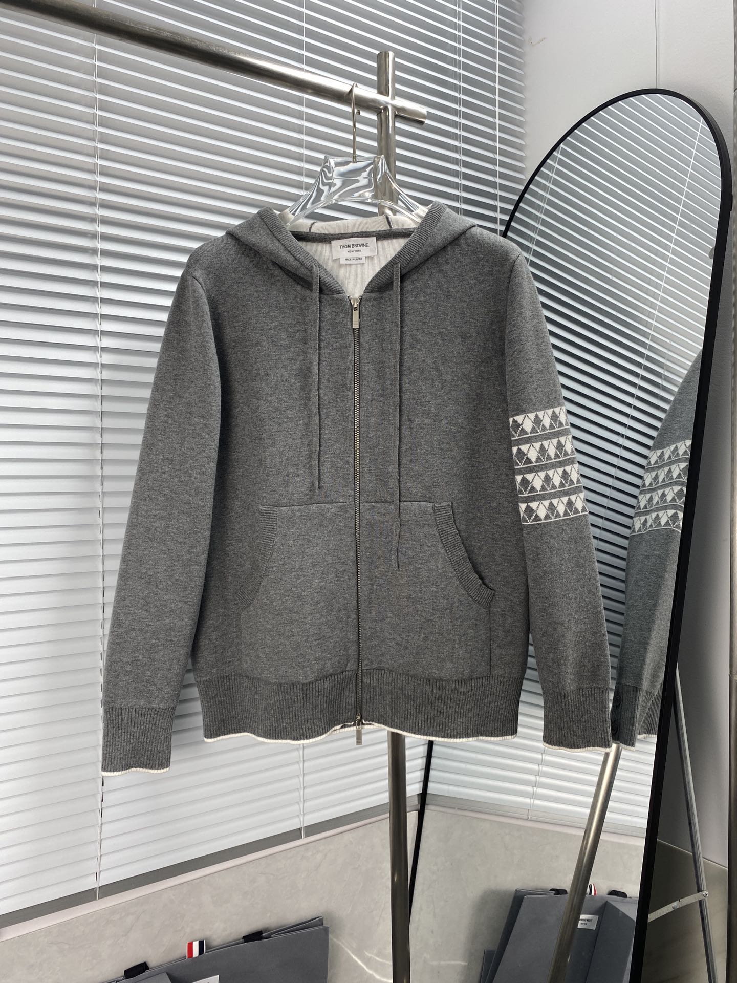 THOM BROWNE «Sudadera con capucha y cremallera con patrón de rombos y perro». Tejido con máquina STOLL alemana de 7.2 d…