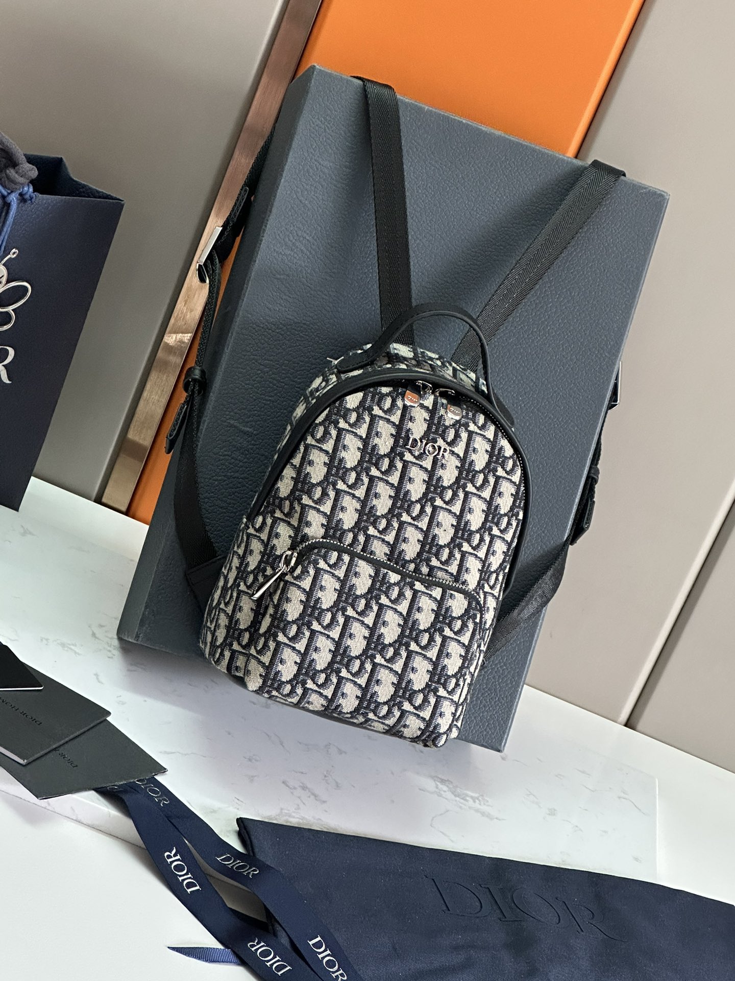 NO:395014,32 Children's Mini Real Photo This Rider backpack is carefully crafted from the Oblique printed fabric of Oblique, drawing inspiration from the Dior men's wardrobe for a practical silhouette. The zippered main compartment and front pocket can hold a variety of small everyday items, with the front decorated with a metal Dior logo. Mini style, light and wear-resistant material, paired with top handles and adjustable shoulder straps, creates the ideal backpack for children. Silver-toned metal Dior logo on the front metal Zipper closure Adjustable shoulder straps Black cowhide Front zipper pocket Dust bag included Model 93338 Mini Backpack Size 24 x 16 x 10 cm Can hold smartphones and AirPods, Dior, Dior, backpacks, cowhide1986090932 儿童迷你 实拍图这款 Rider 双肩背包采用米色和蓝色 Oblique 印花面料精心制作,从 Dior 男士衣橱汲取灵感,打造实用的廓形.拉链主隔层和正面口袋可收纳各种小件日常用品,正面饰以金属 Dior 标志.迷你款式,材质轻盈而耐磨,搭配顶部手柄和可调节肩带,为儿童打造理想的双肩背包. 正面银色调金属 Dior 标志 金属拉链开合 可调节肩带 黑色牛皮革手柄 正面拉链口袋 内含防尘袋 型号93338迷你书包 尺寸24 x 16 x 10 厘米 可收纳智能手机和 AirPods,迪奥,dior,dior,backpacks,cowhide,Bag