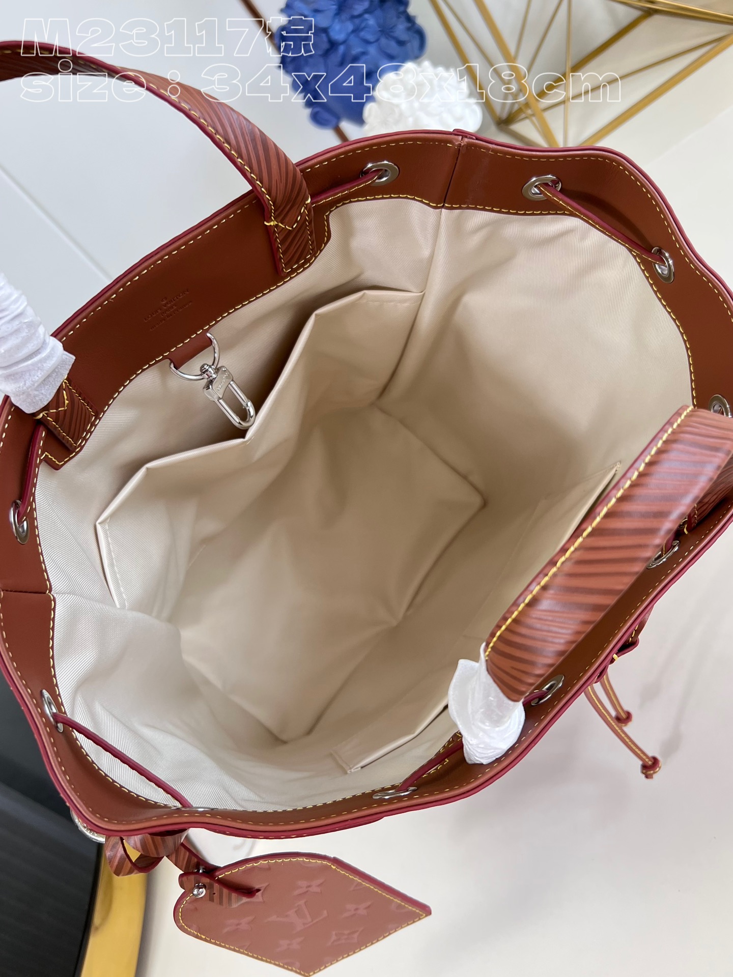 The bag features a spacious interior secured with a drawstring closure - Bag 8
