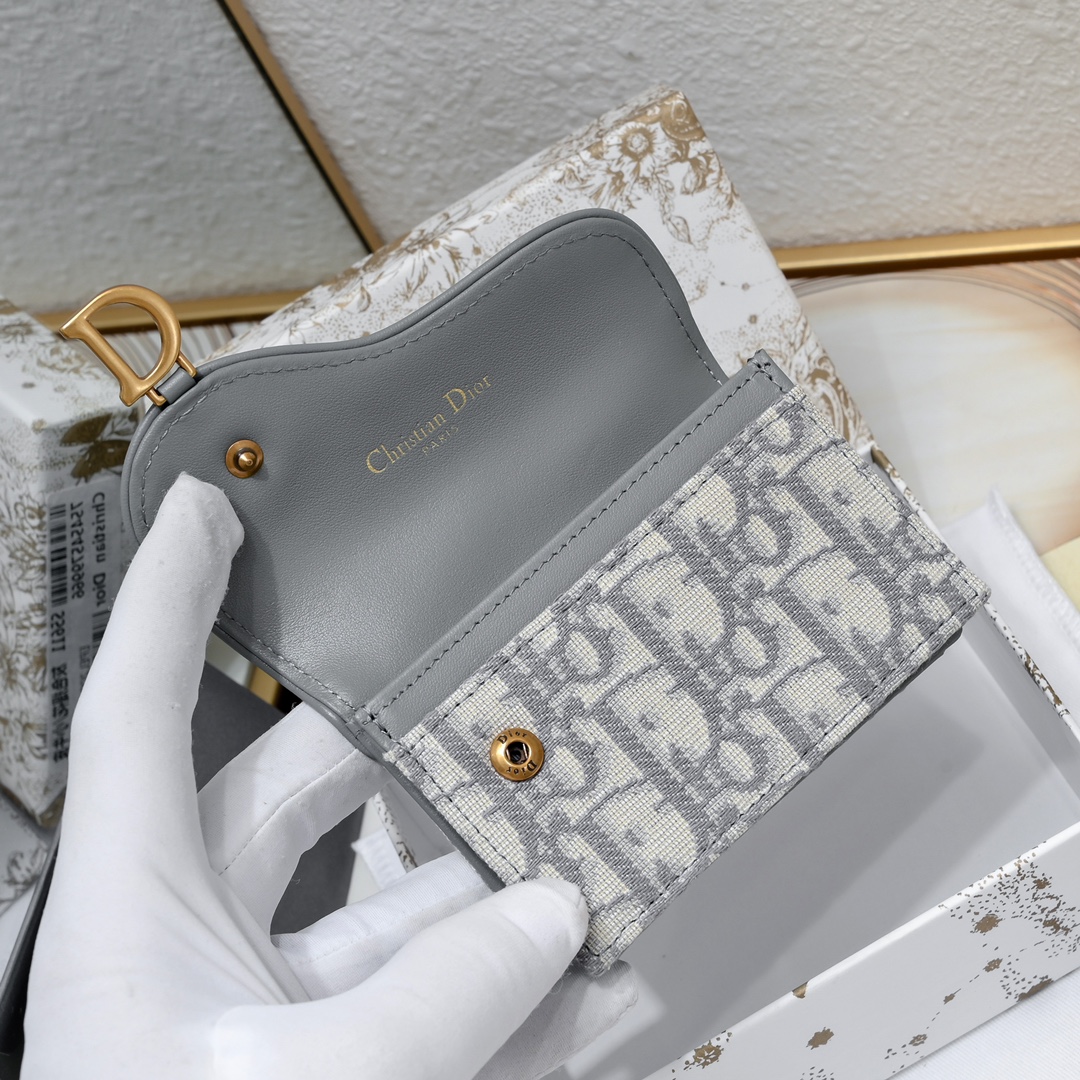 Dior ObliqueSaddle零钱包非常有辨识度的马鞍形状已经成为了D家的代表性元素外面的盖子是一个手枪造型标志性的字母D作装饰如今小包当道摆脱大钱包换上一个小巧 的卡包/零钱包就妥妥当当啦~