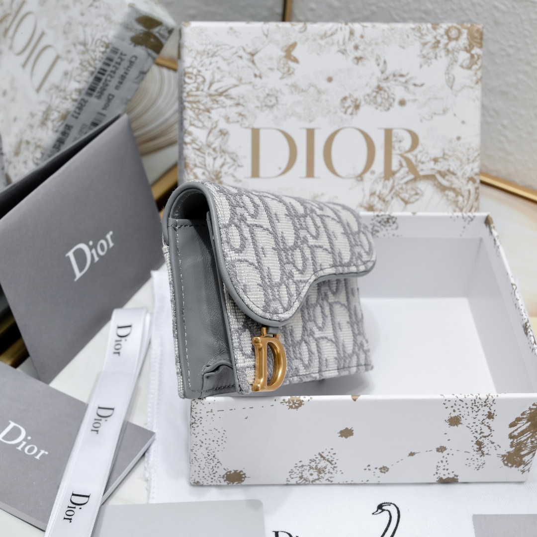 Dior ObliqueSaddle零钱包非常有辨识度的马鞍形状已经成为了D家的代表性元素外面的盖子是一个手枪造型标志性的字母D作装饰如今小包当道摆脱大钱包换上一个小巧 的卡包/零钱包就妥妥当当啦~