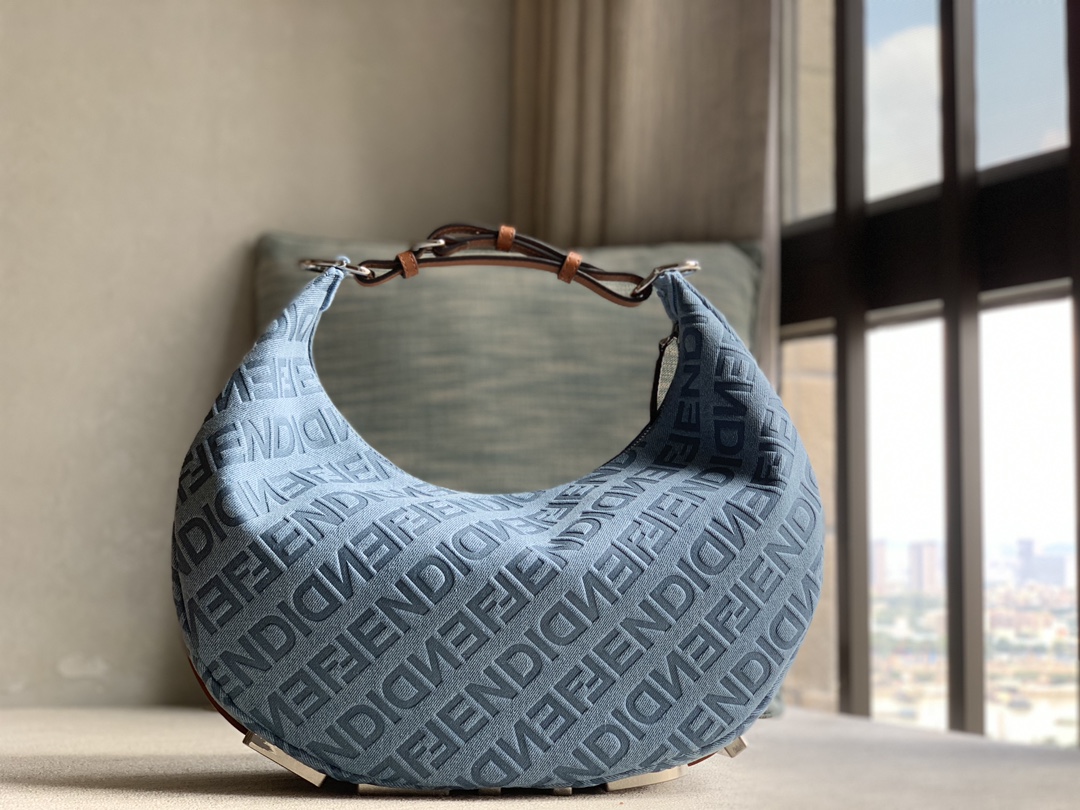 Fendi large crescent bag, made of light blue denim, Fendi decorated with FENDI Mirror pattern all over, brown cowhide details. When the handbag i