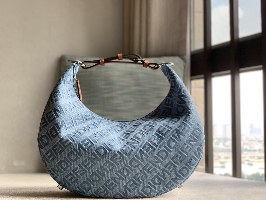 Fendi large crescent bag, made of light blue denim, Fendi decorated with FENDI Mirror pattern all over, brown cowhide details. When the handbag i