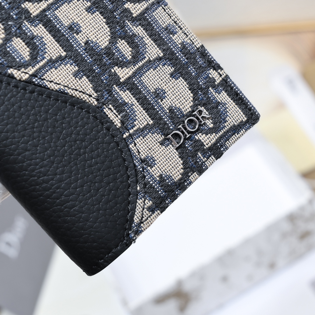 Dior 黑色细工镶嵌粒面牛皮革搭配米色和黑色Oblique印花面料正面金属覆层黄铜Dr标志内侧饰有D压花标志双折款式
