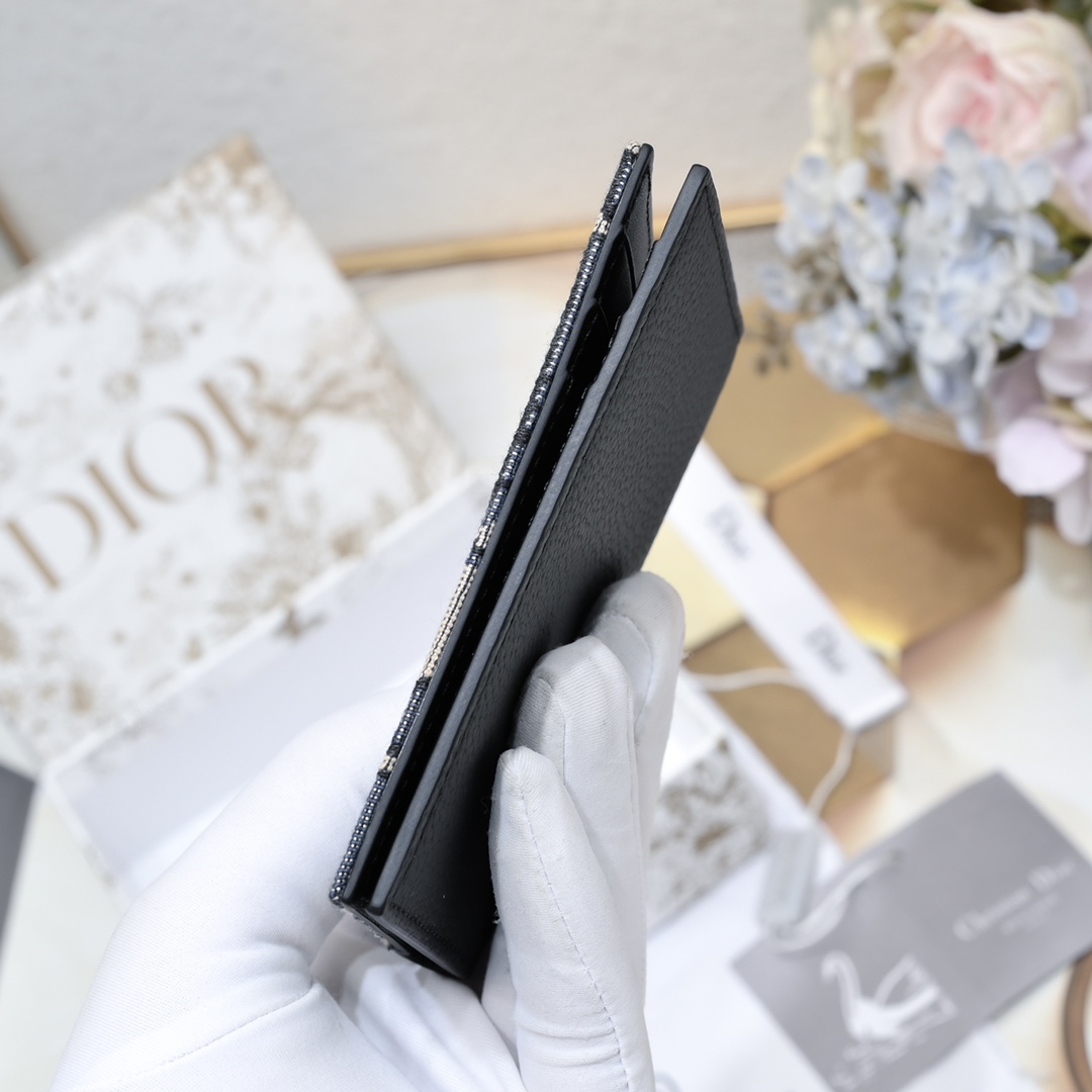 Dior 黑色细工镶嵌粒面牛皮革搭配米色和黑色Oblique印花面料正面金属覆层黄铜Dr标志内侧饰有D压花标志双折款式