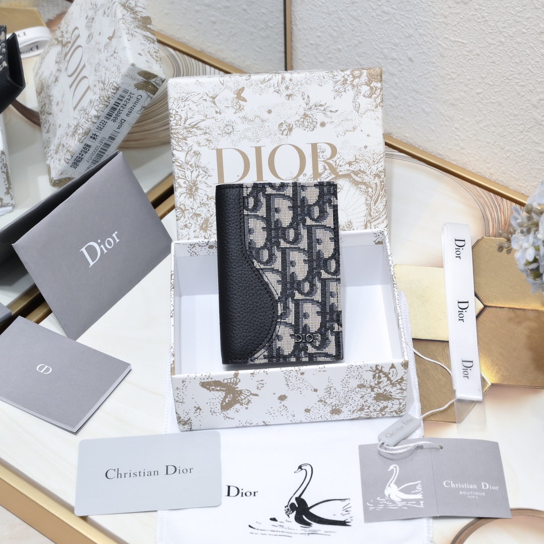 Dior 黑色细工镶嵌粒面牛皮革搭配米色和黑色Oblique印花面料正面金属覆层黄铜Dr标志内侧饰有D压花标志双折款式