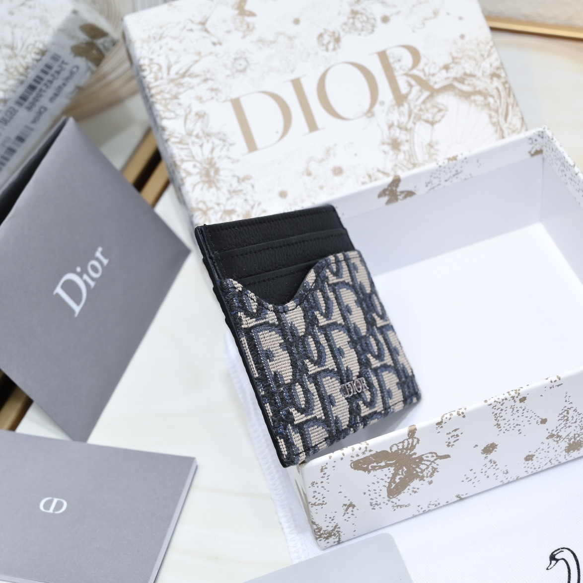 Dior 黑色粒面牛皮革搭配米色和黑色Oblique印花面料正面金属覆层黄铜Dr标志内侧饰有Dr压花标志正面3个卡槽背面3个卡槽顶部1个卡槽内含防尘袋
