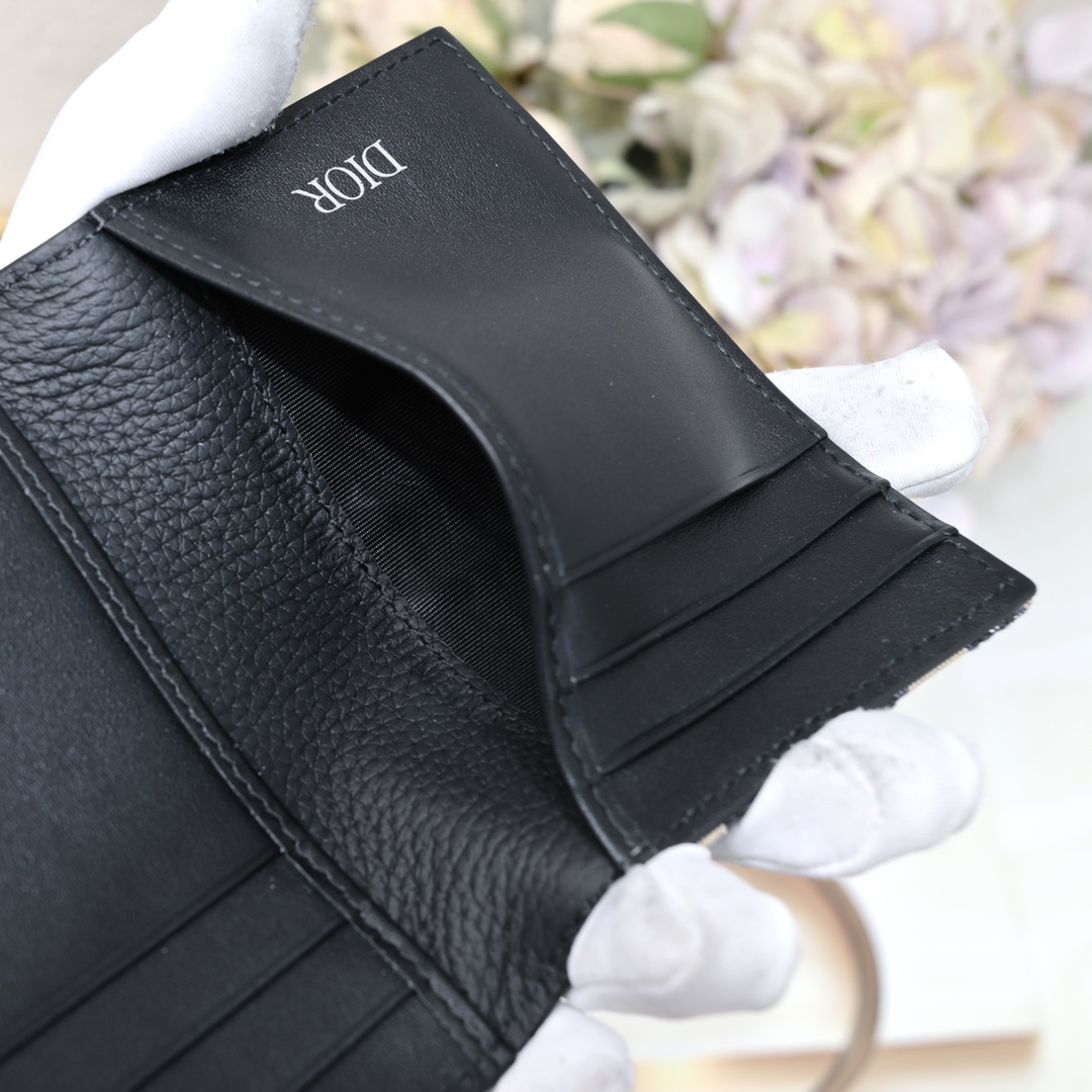 Dior 黑色细工镶嵌粒面牛皮革搭配米色和黑色Oblique印花面料正面金属覆层黄铜Dr标志内侧饰有D压花标志双折款式