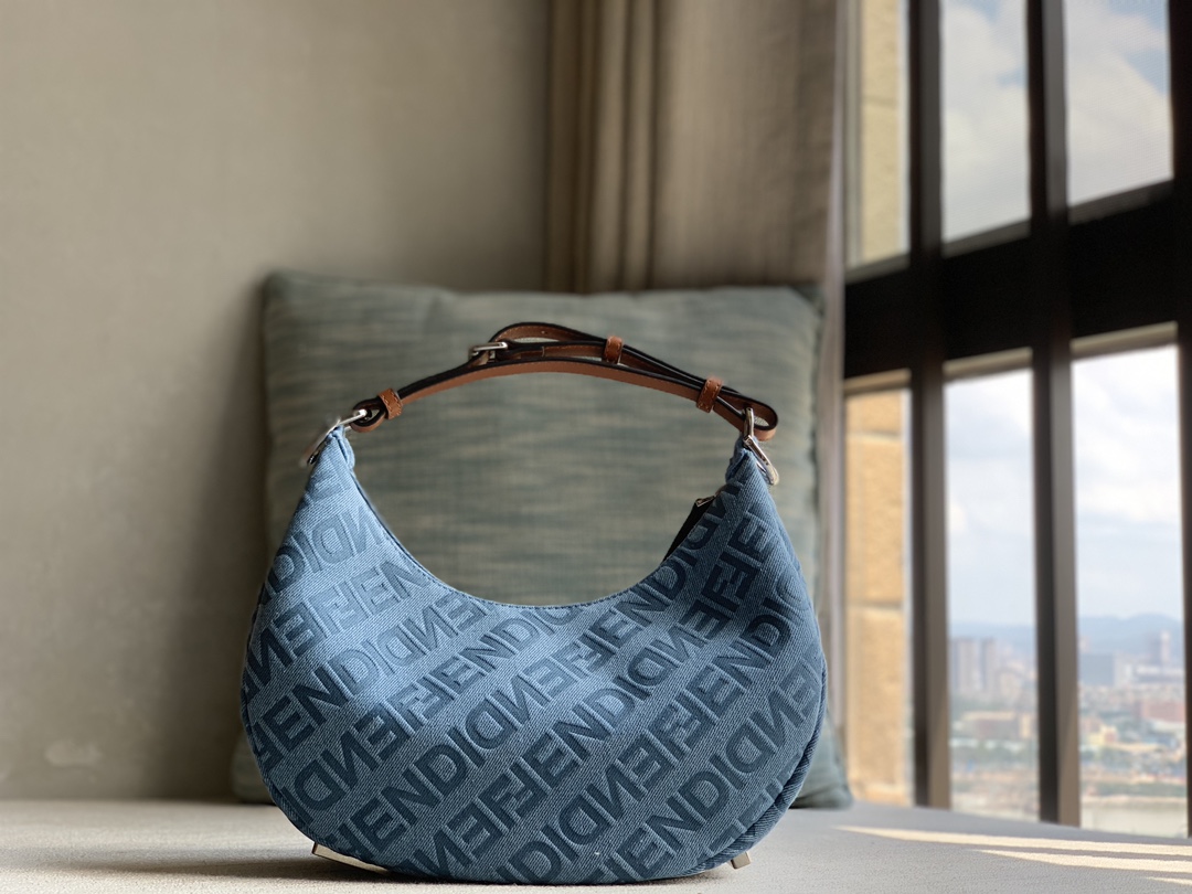 Fendi small crescent bag, made of light blue denim, FENDI Mirror pattern all over, brown cowhide details. When the handbag is carried under the a