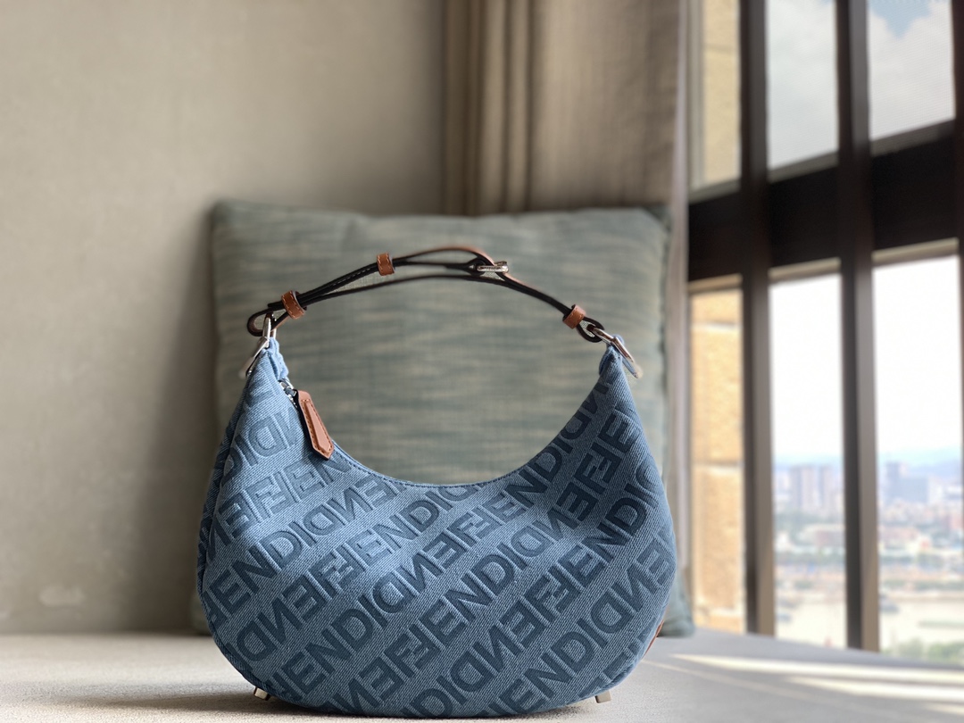 Fendi small crescent bag, made of light blue denim, FENDI Mirror pattern all over, brown cowhide details. When the handbag is carried under the a
