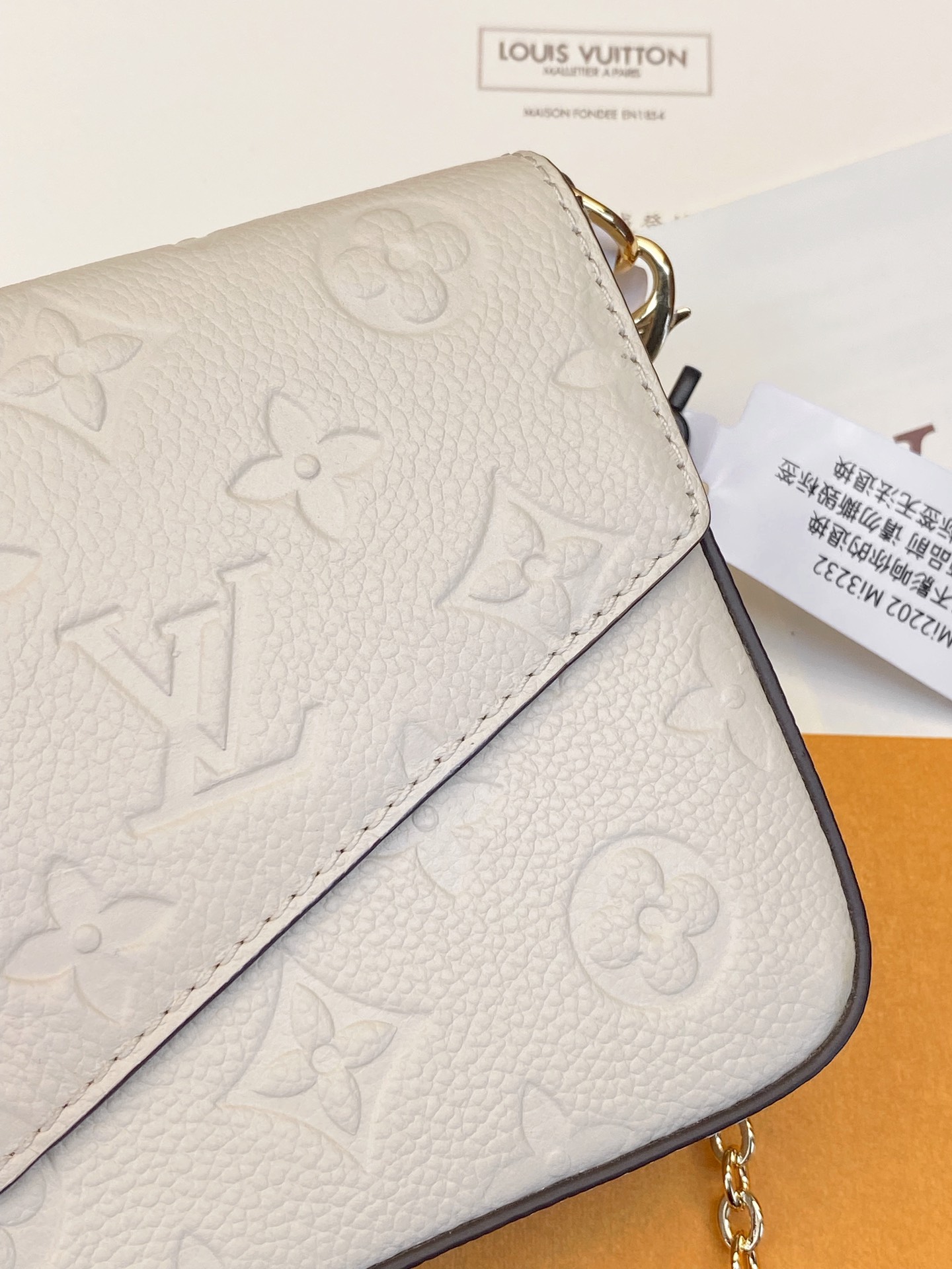 米白色 Pochette Félicie 链条包为 Monogram Empreinte 皮革压印路易威登标志性 Monogram 图案